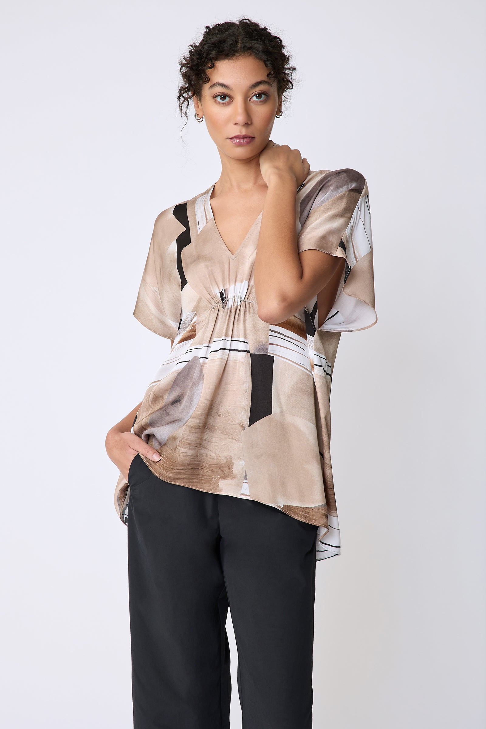 Kal Rieman Paloma Top in Sante Fe print Sand on model front view hand on cheek
