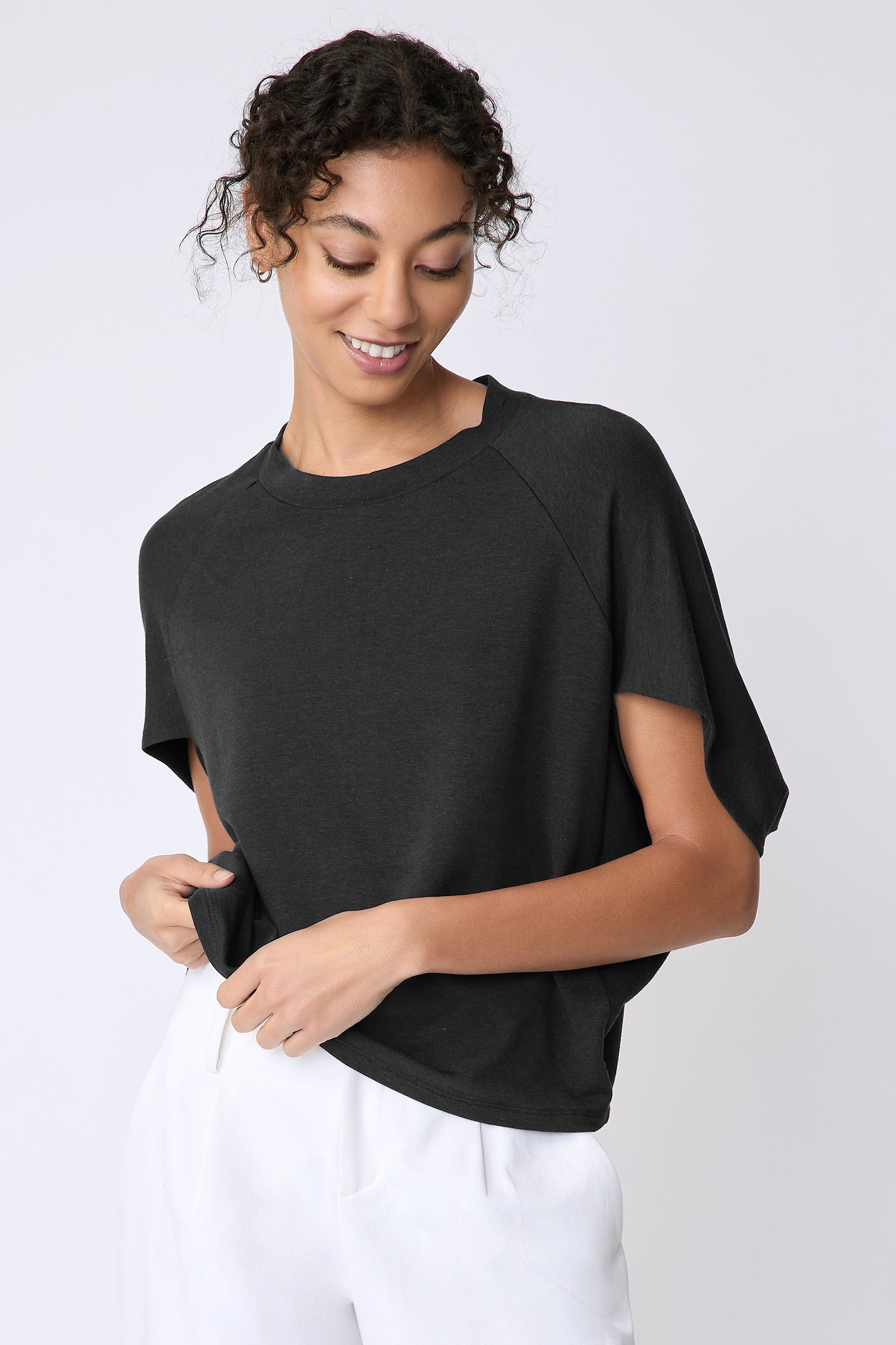 Kal Rieman Phoenix Cape Top in black on model front view detail holding hem