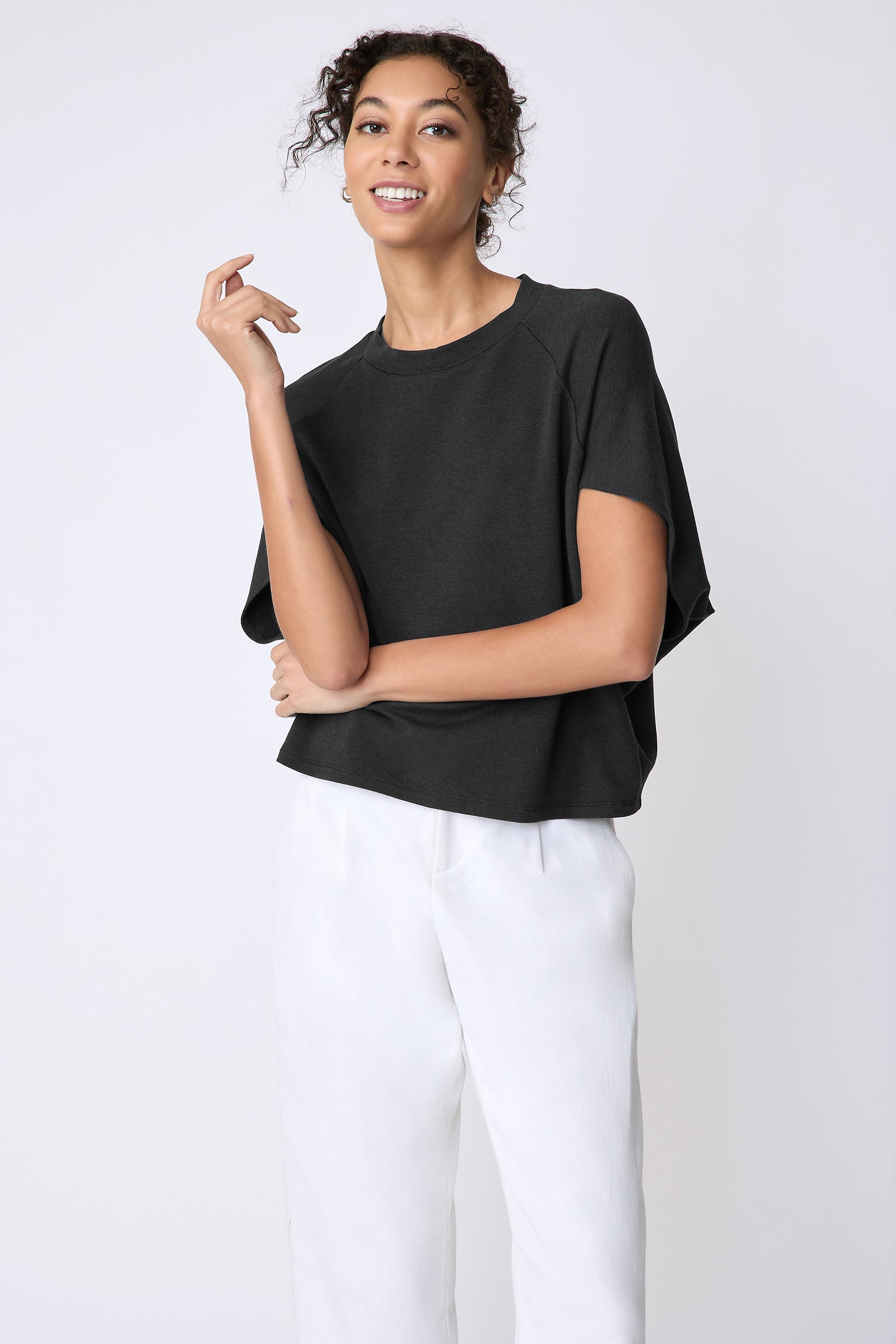 Kal Rieman Phoenix Cape Top in black on model front view hand at face