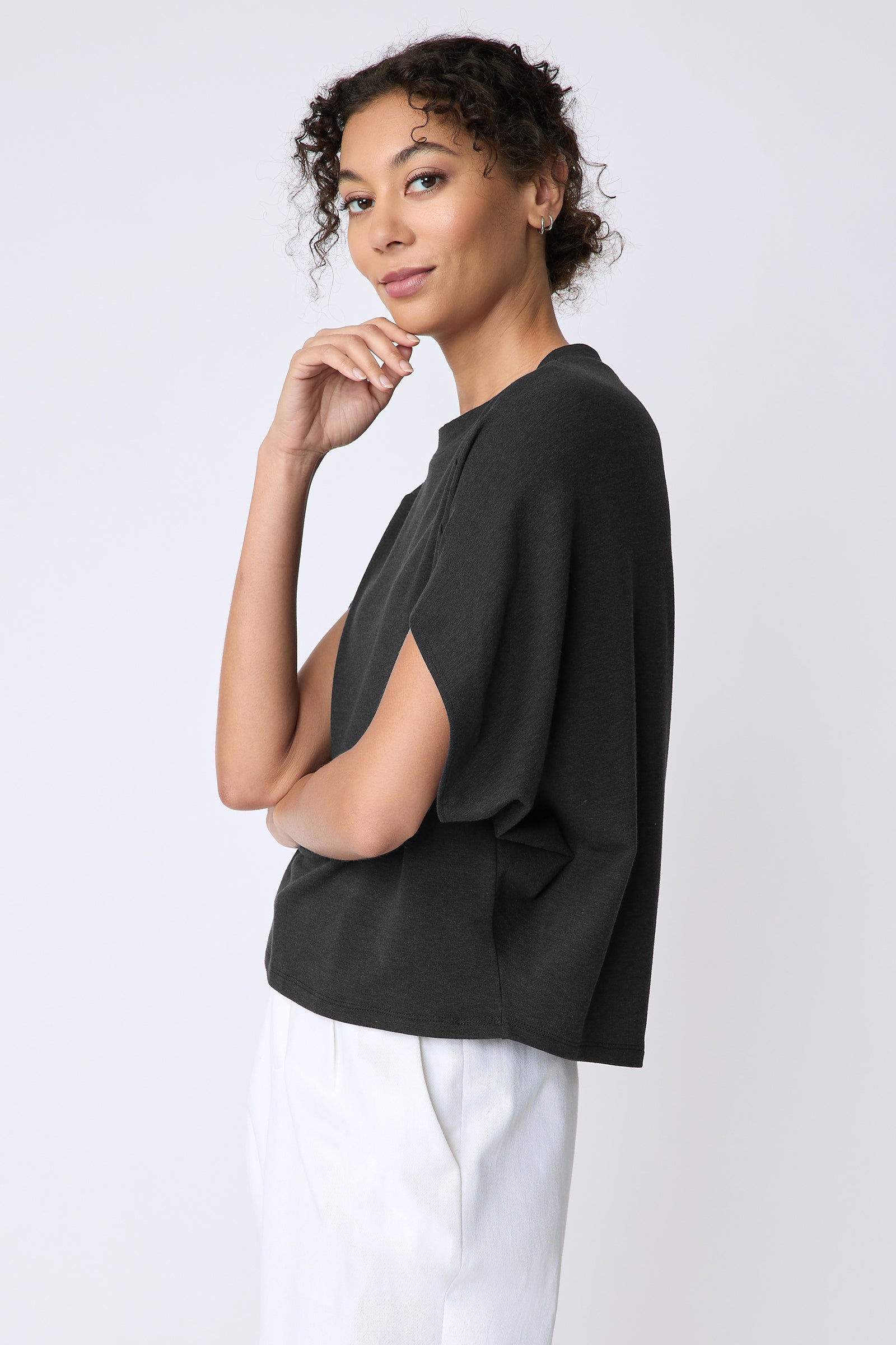 Kal Rieman Phoenix Cape Top in black on model side view hand on face