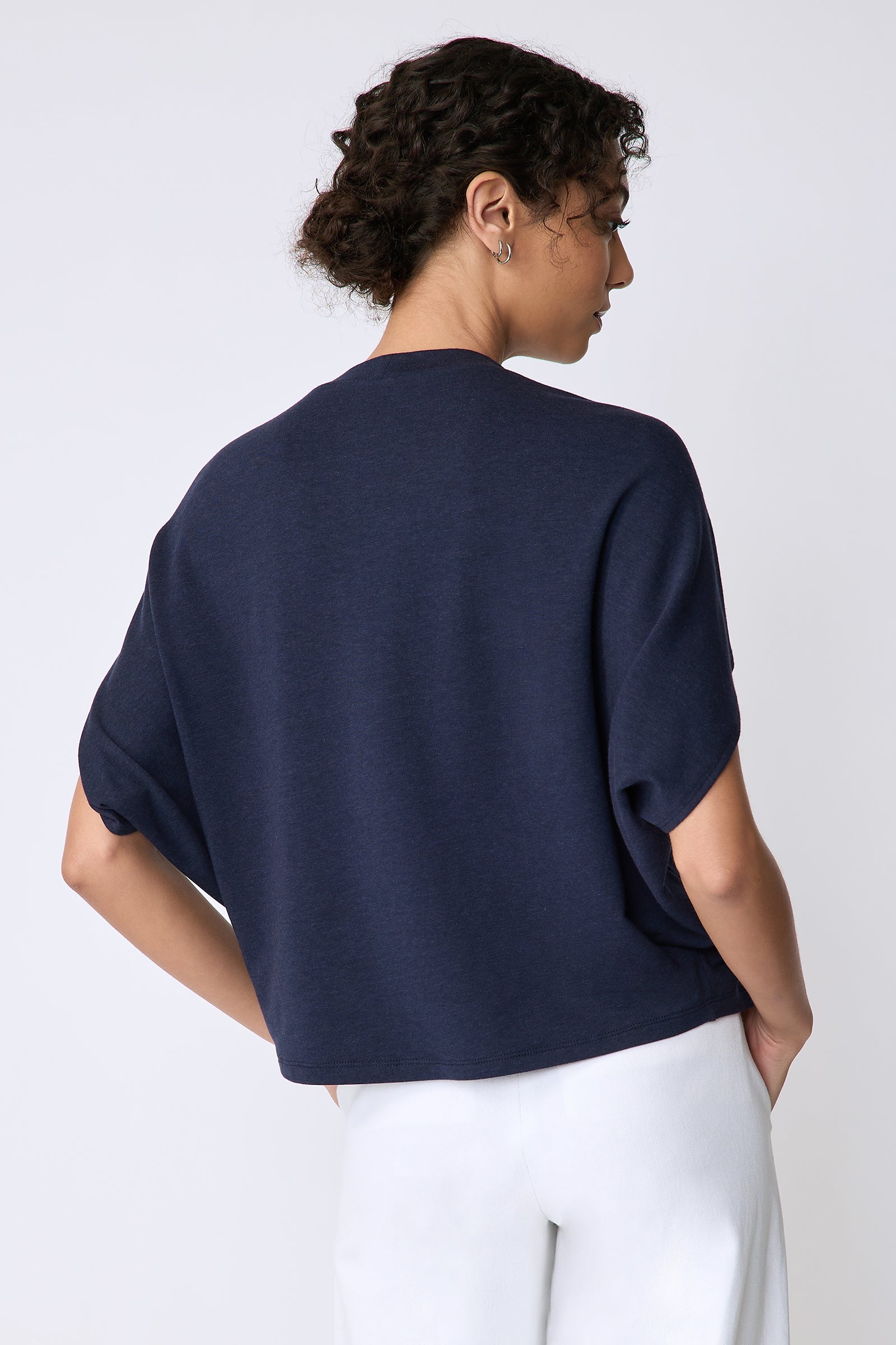 Kal Rieman Phoenix Cape Top in navy on model back view hands in pockets