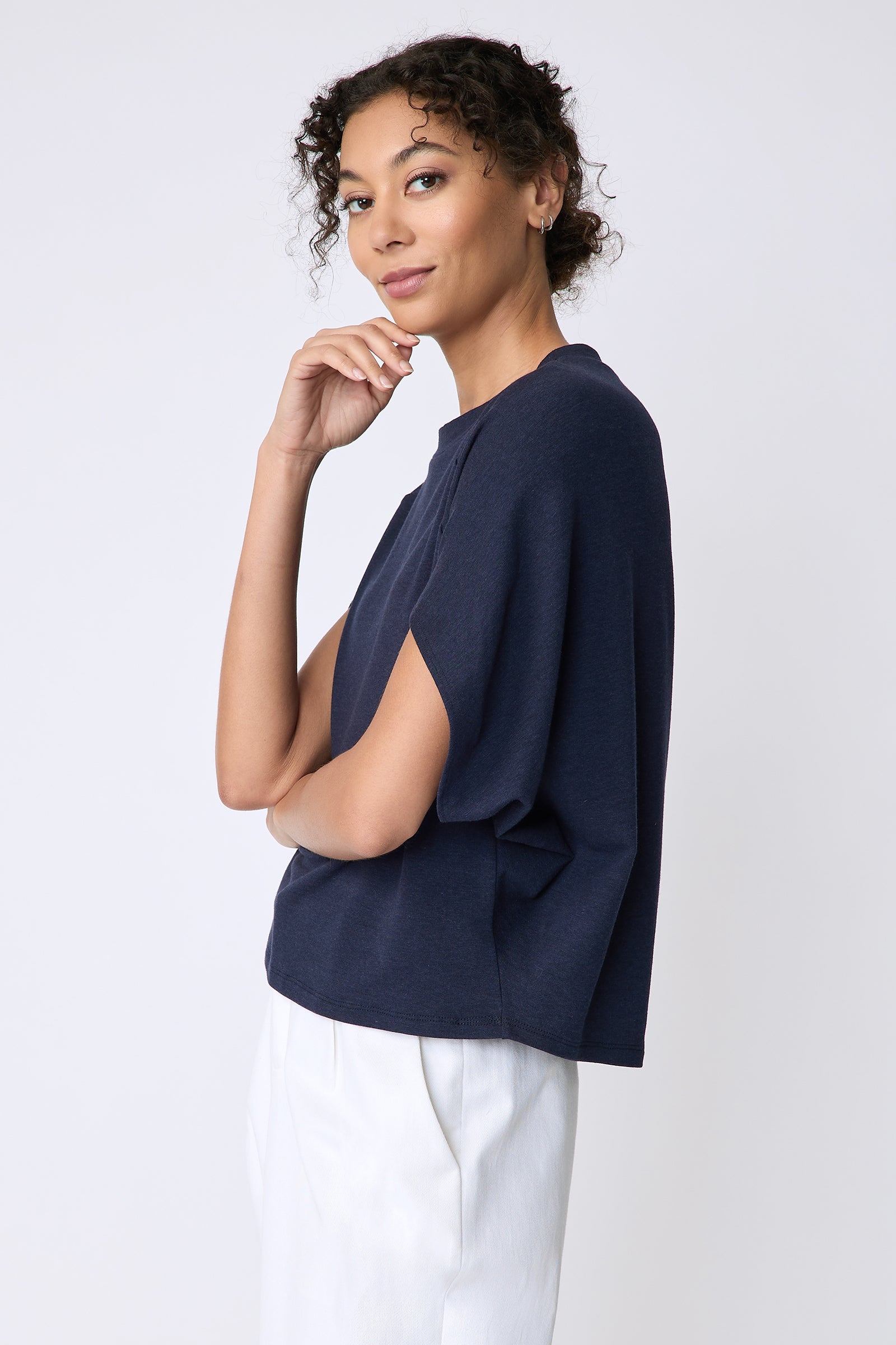 Kal Rieman Phoenix Cape Top in navy on model side view hand on face