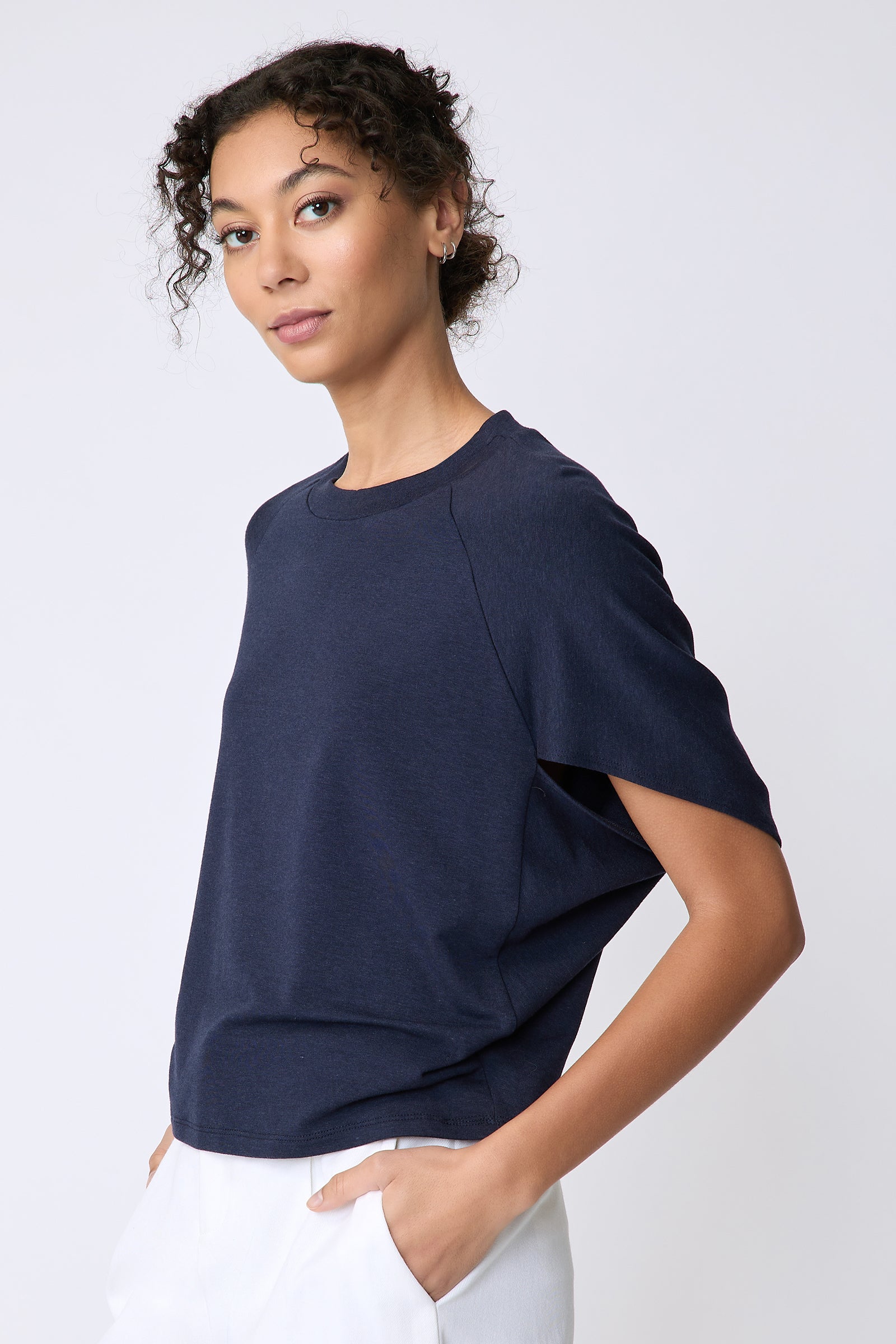 Kal Rieman Phoenix Cape Top in navy on model side view hands in pockets