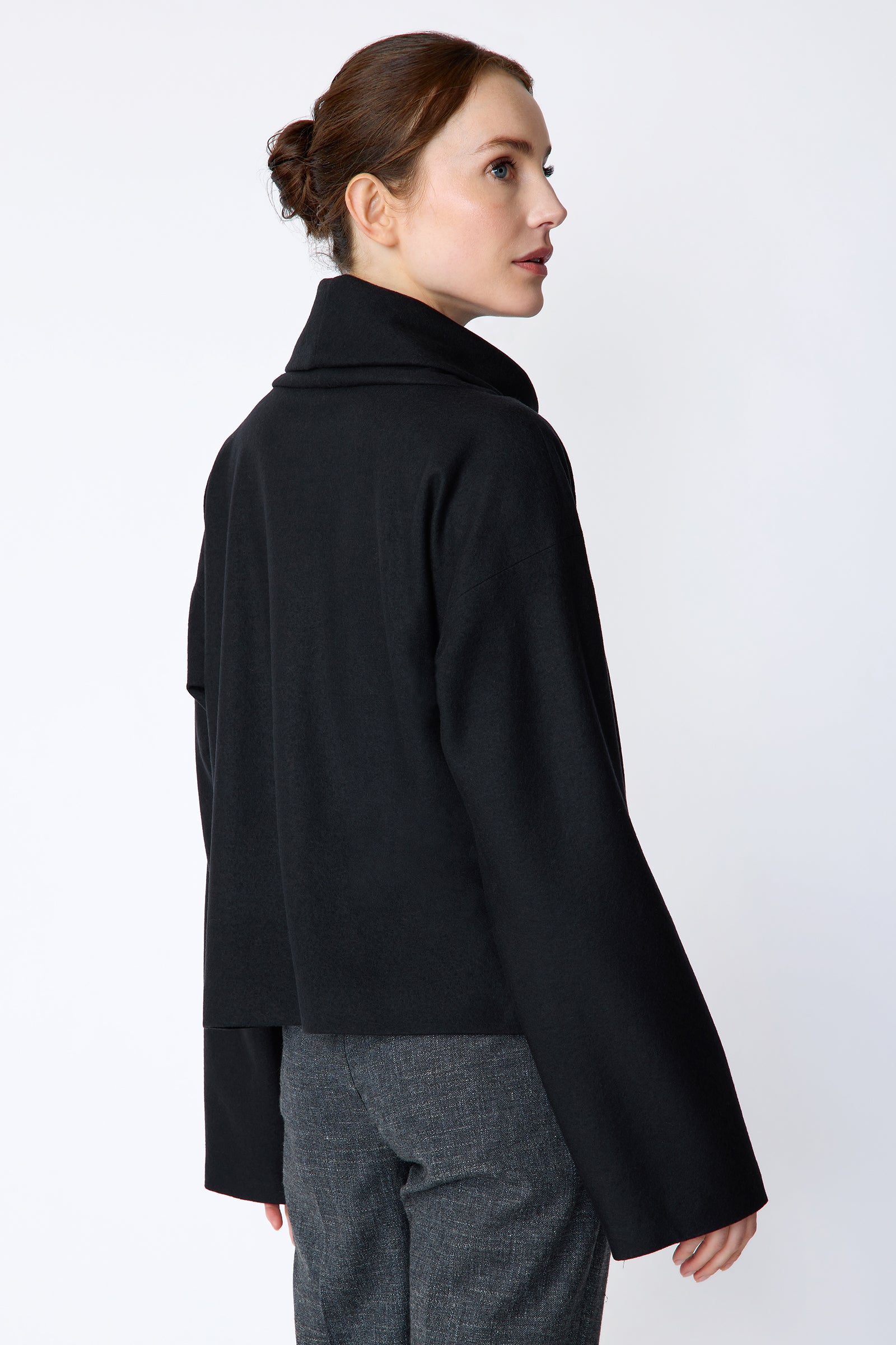 Woman wearing Kal Rieman Polina Tneck Pullover in midnight and Kal Rieman Martine Trouser in Indigo Denim on a white background, arm crossed over, full front view