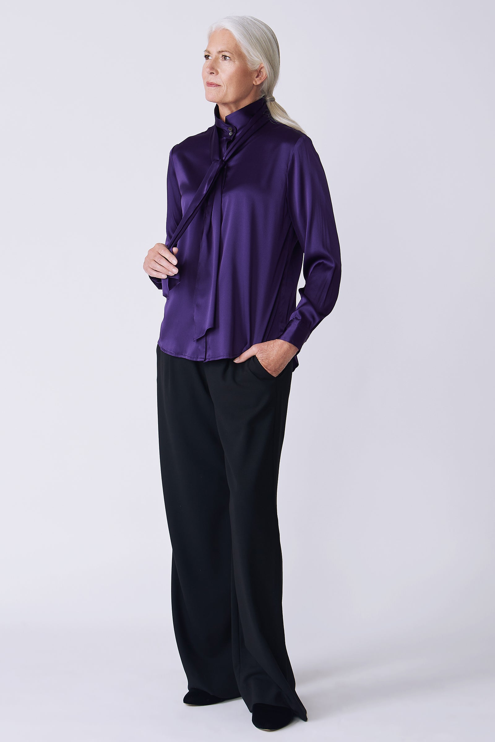 Kal Rieman Regency Silk Blouse in royal purple color charmeuse on model side view holding scarf