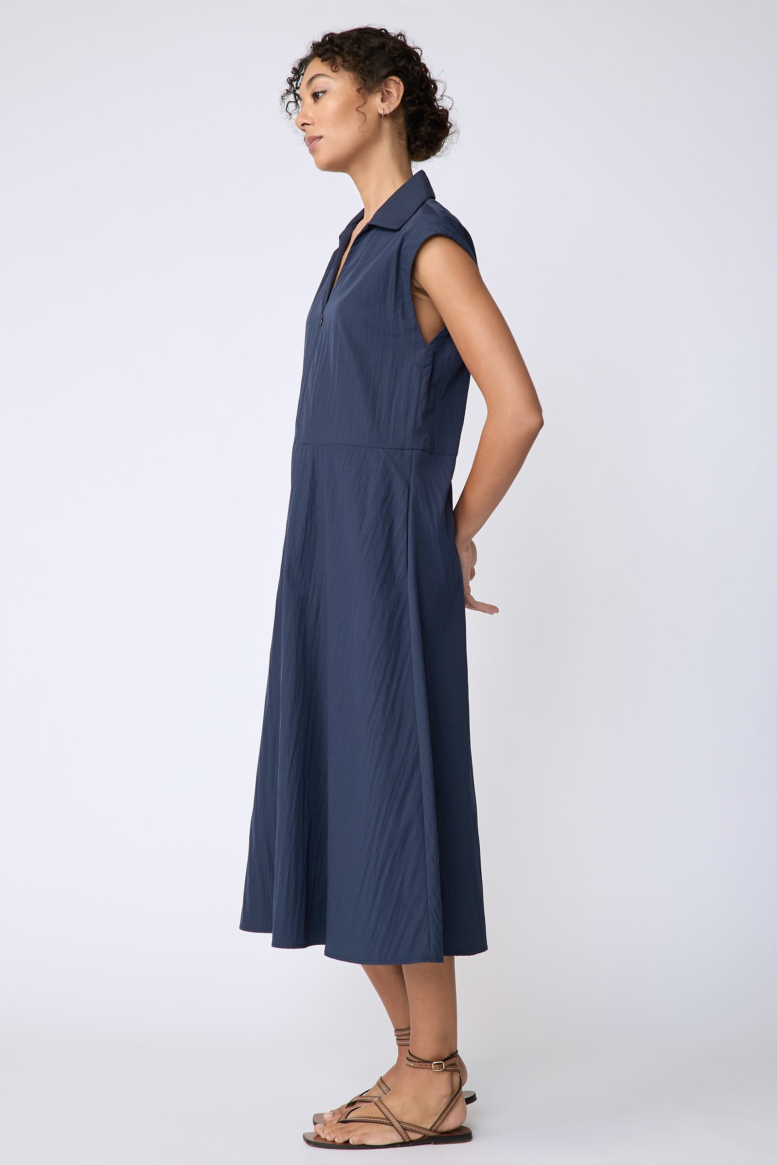 Kal Rieman Savannah Dress in navy typewriter cloth on model side view hands behind back