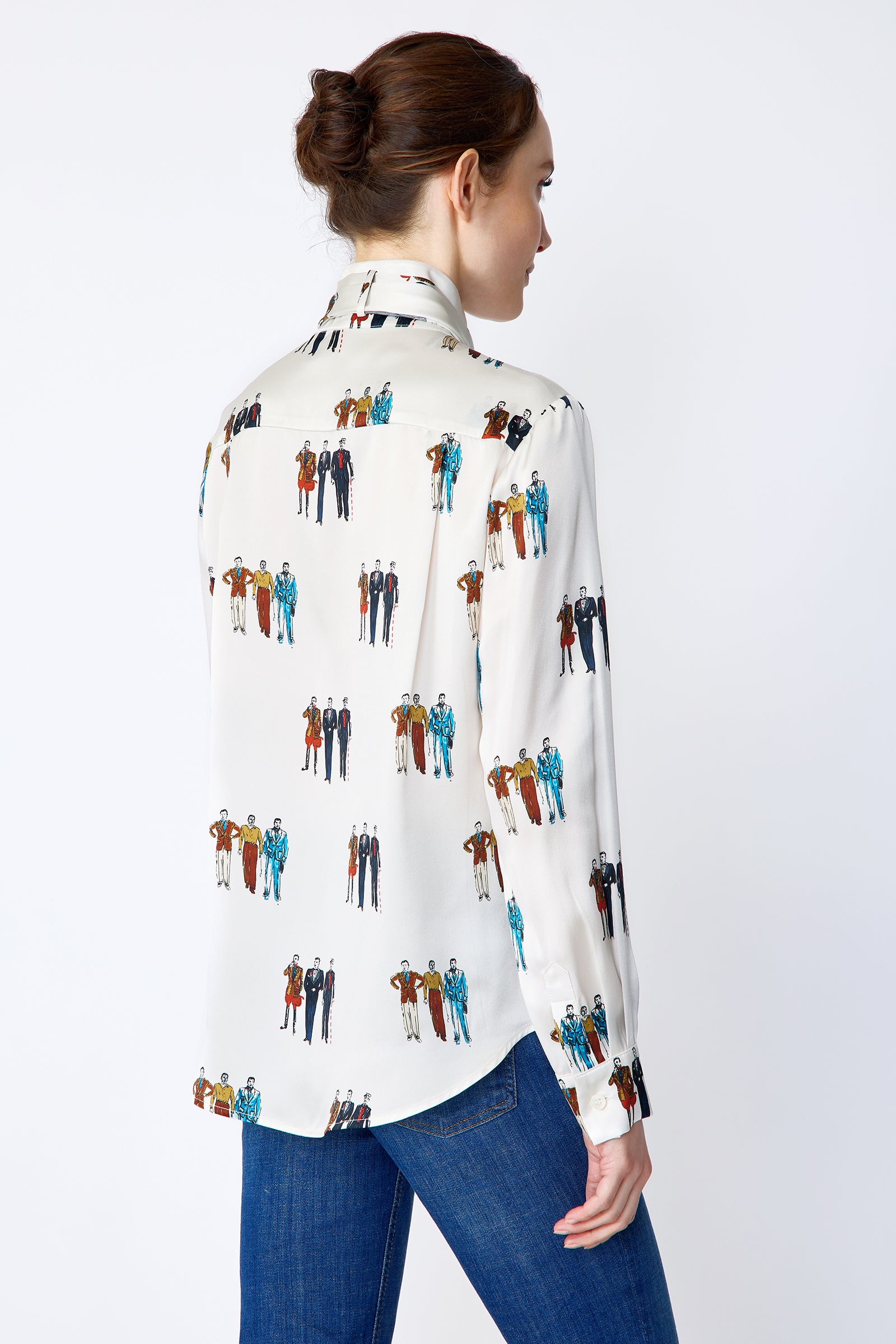 Woman wearing Kal Rieman Silk Regency Blouse in Dandy Print with black pants leaning on a piano holding a baton look book image