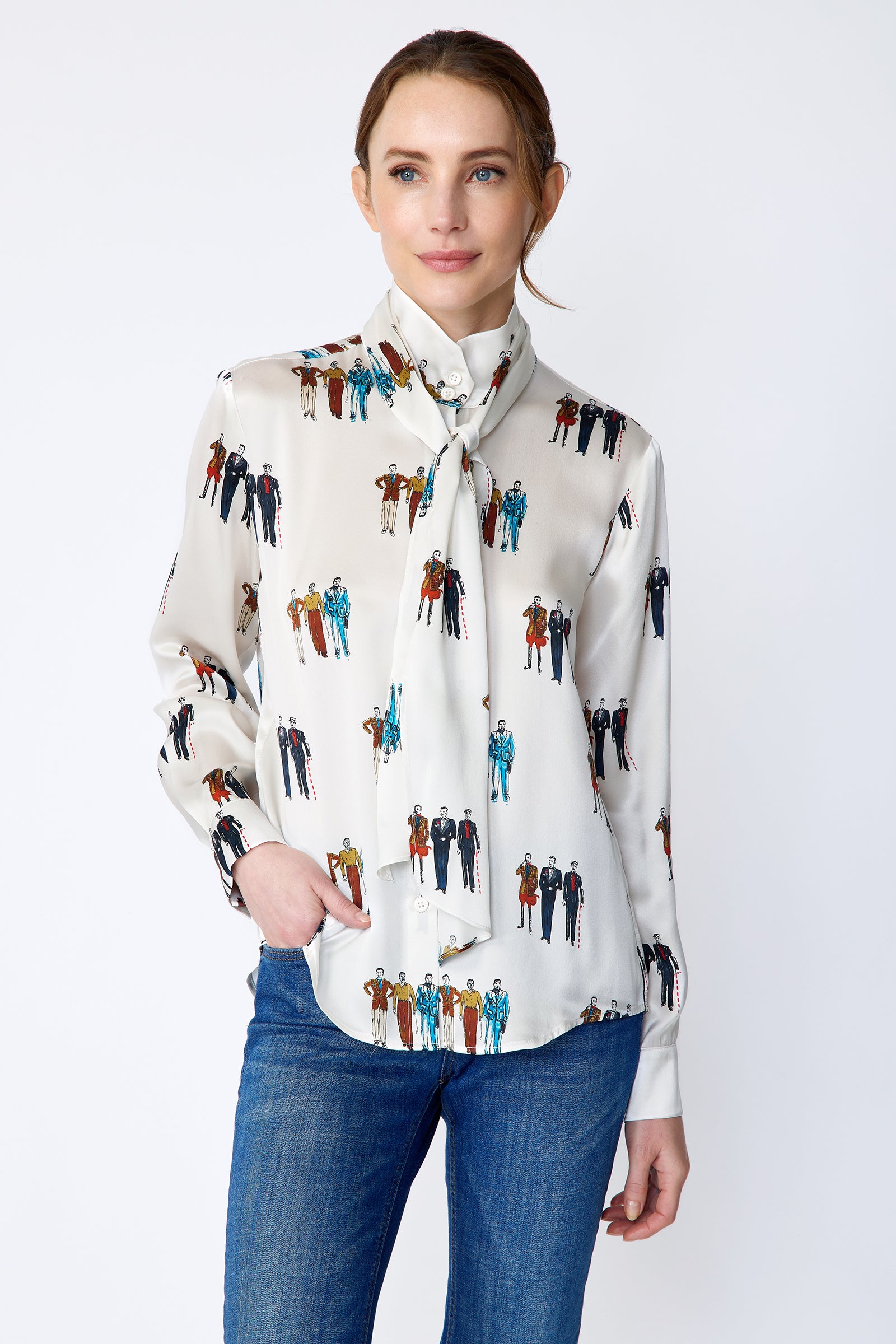 Woman wearing Kal Rieman Silk Regency Blouse in Dandy Print with blue jeans on a white background, hand in pocket, arm on side close view