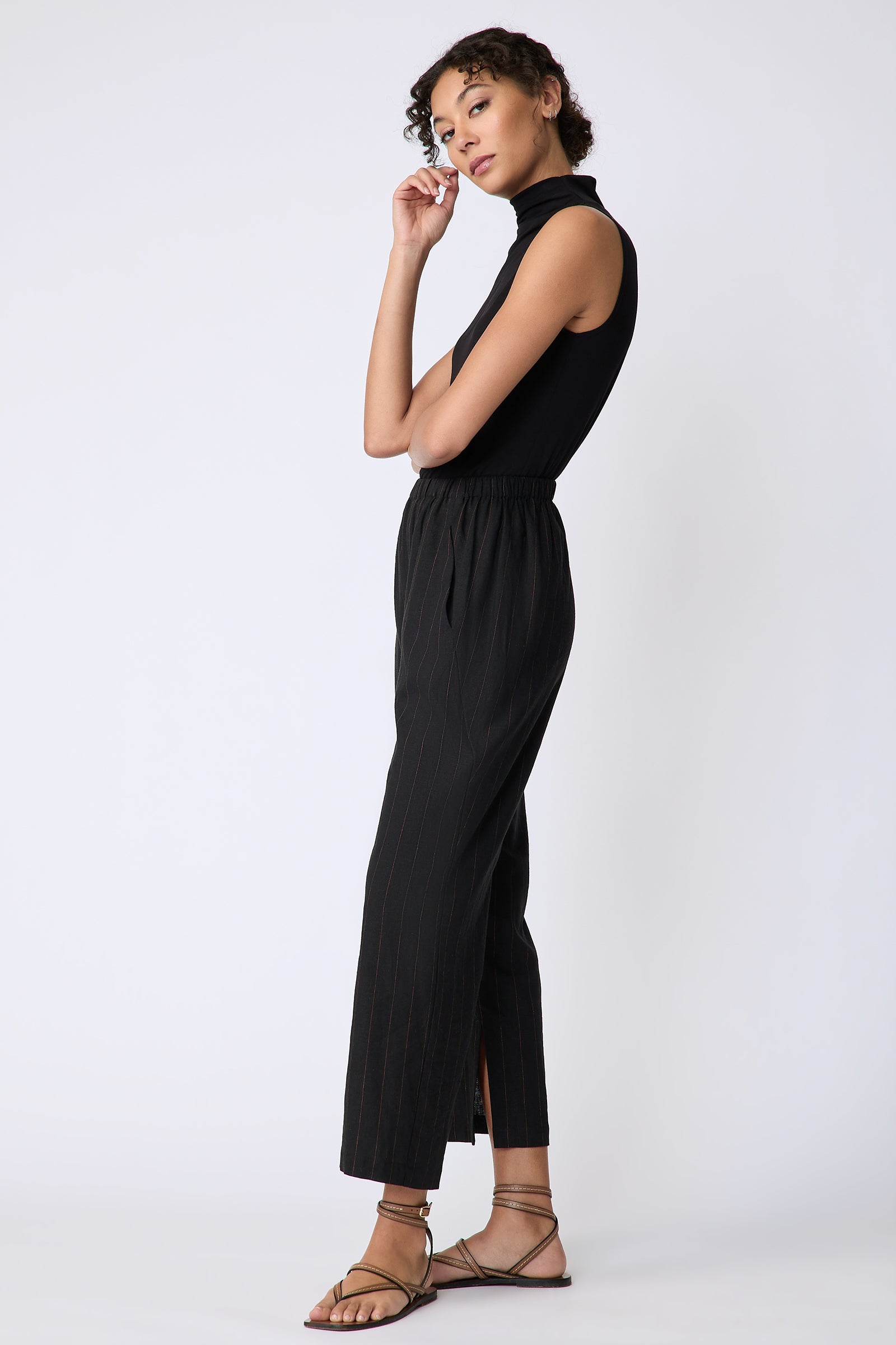Kal Rieman Split Hem Capri in black pinstripe linen on model side view hand at face