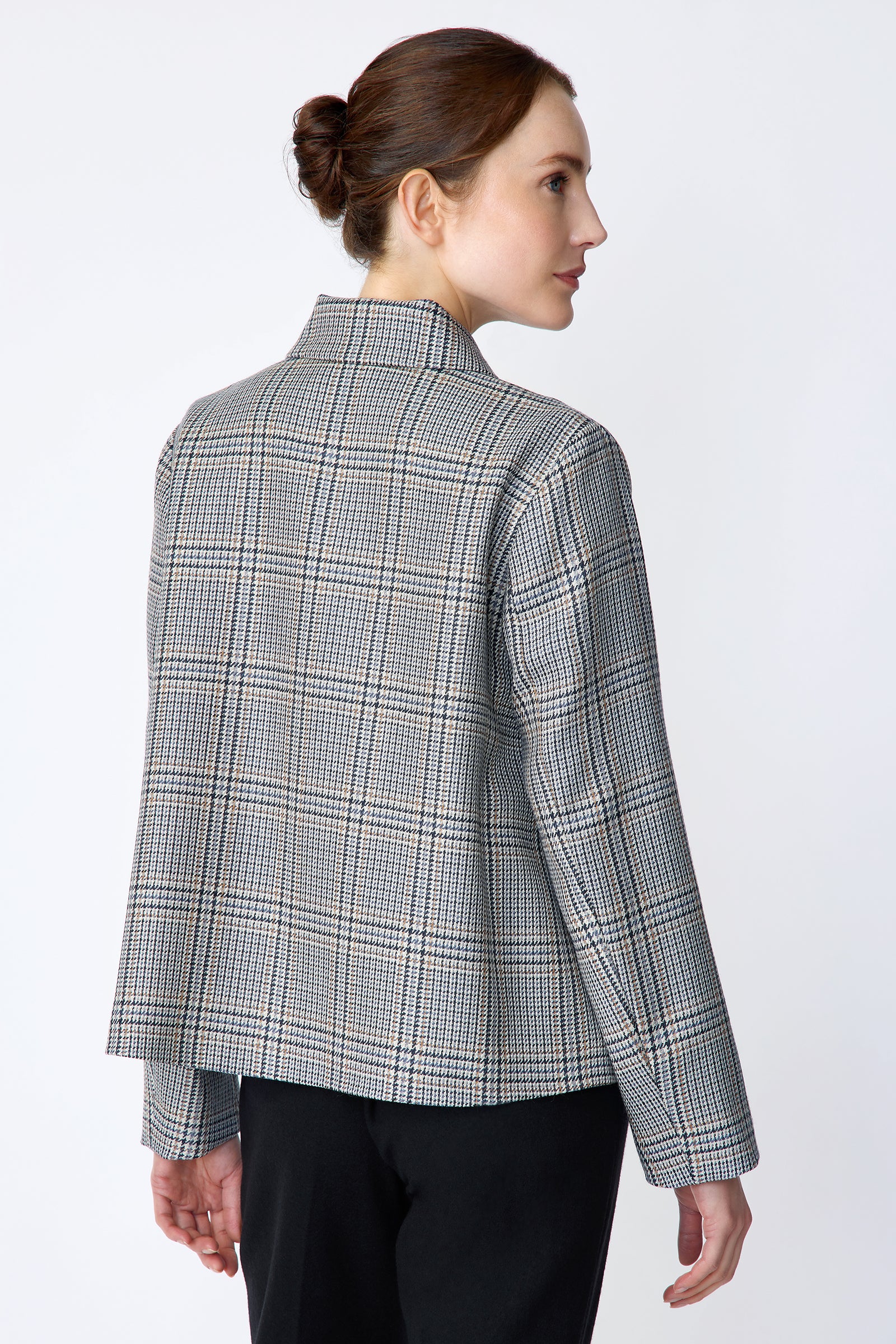 Woman wearing Kal Rieman Sylvie Swing Jacket in Italian Glen Plaid and black pants on a white background arms on the side back view
