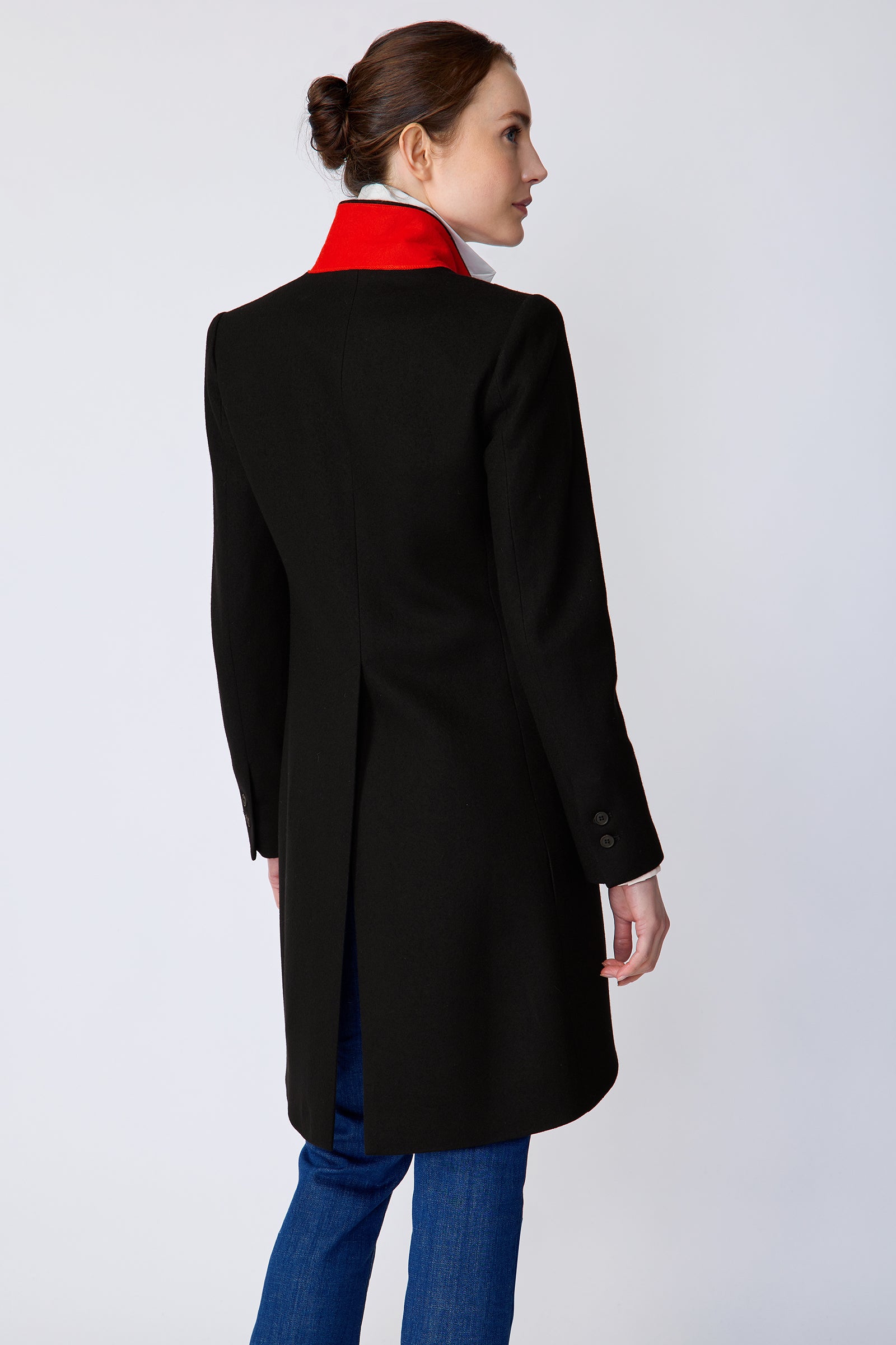 Woman wearing Kal Rieman Tailored Tux Blazer in Black, Collar unfolded, with blue jeans and brown shoes, arms on the side, back view, looking sideways