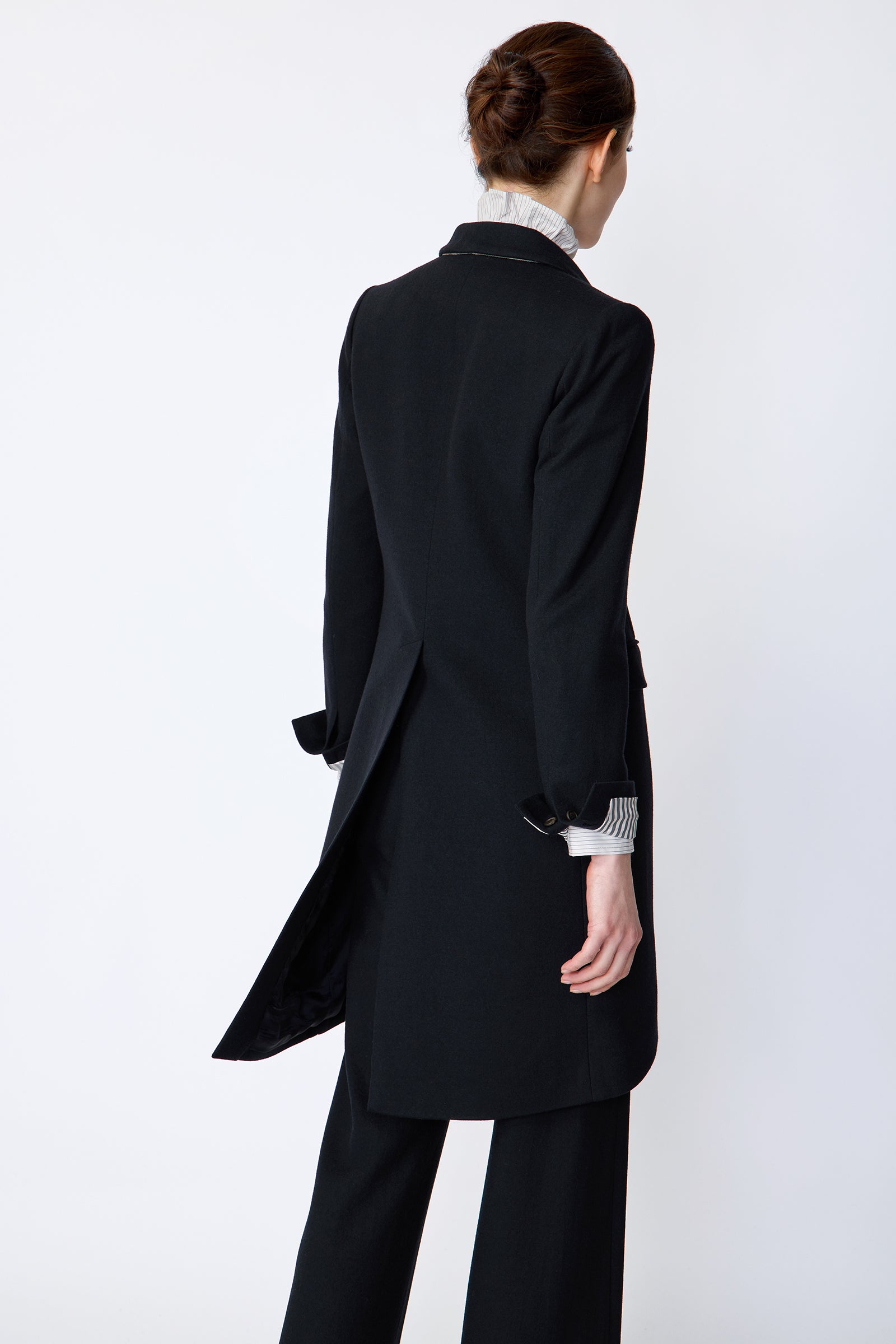 Woman wearing Kal Rieman Tailored Tux Blazer in Midnight over Kal Rieman Amy Ruffle Collar shirt with Kal Rieman felted Jersey Wide Leg pants in midnight, arms on the side, back view