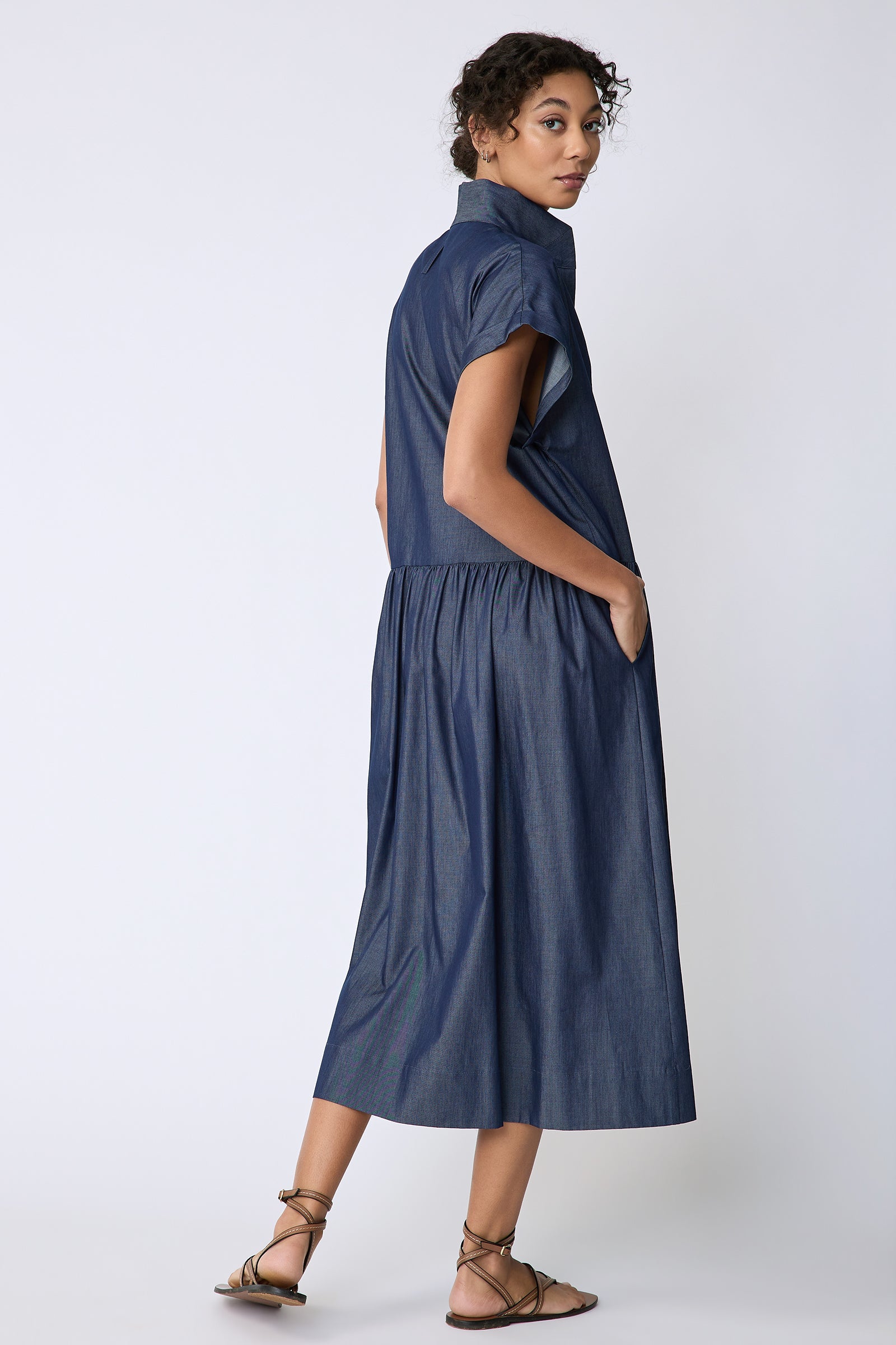 Kal Rieman Tanya Dress in Indigo light weight denim on model back view hands in pockets