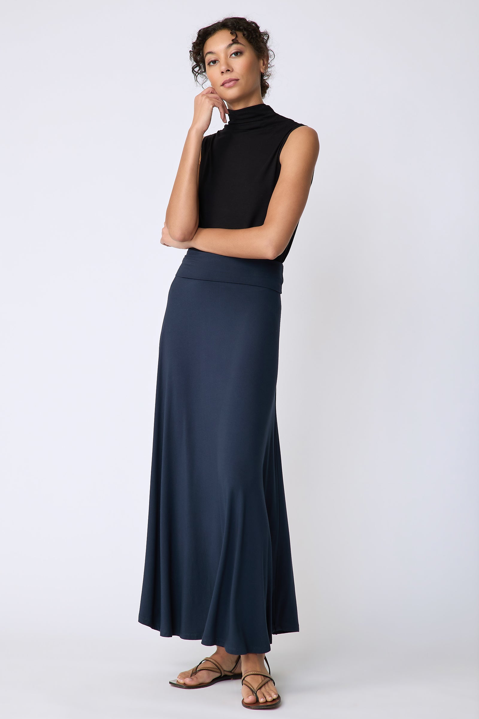 Kal Rieman Thea Kick Skirt in navy bamboo jersey on model front view hand on cheek