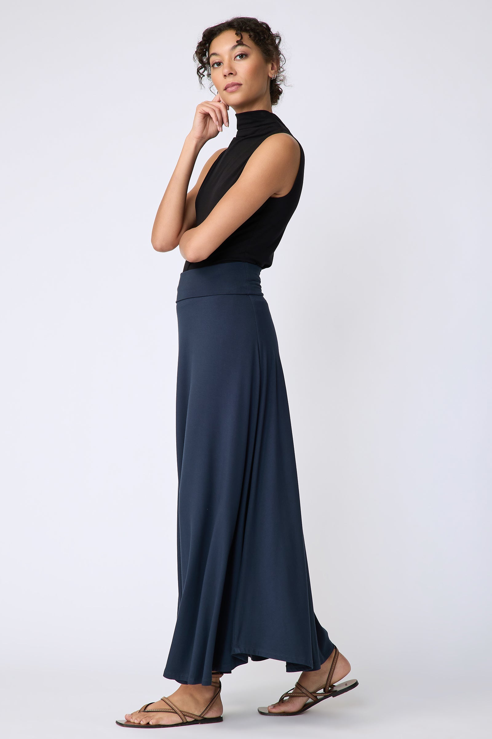 Kal Rieman Thea Kick Skirt in navy bamboo jersey on model side view walking hand on chin