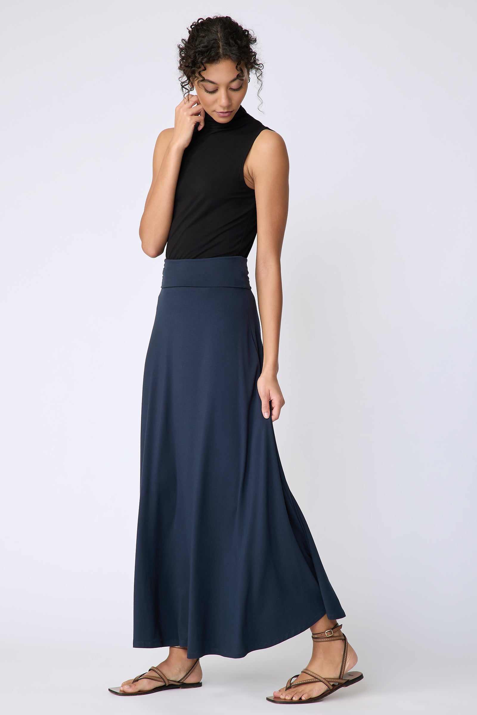 Kal Rieman Thea Kick Skirt in navy bamboo jersey on model side view walking holding skirt
