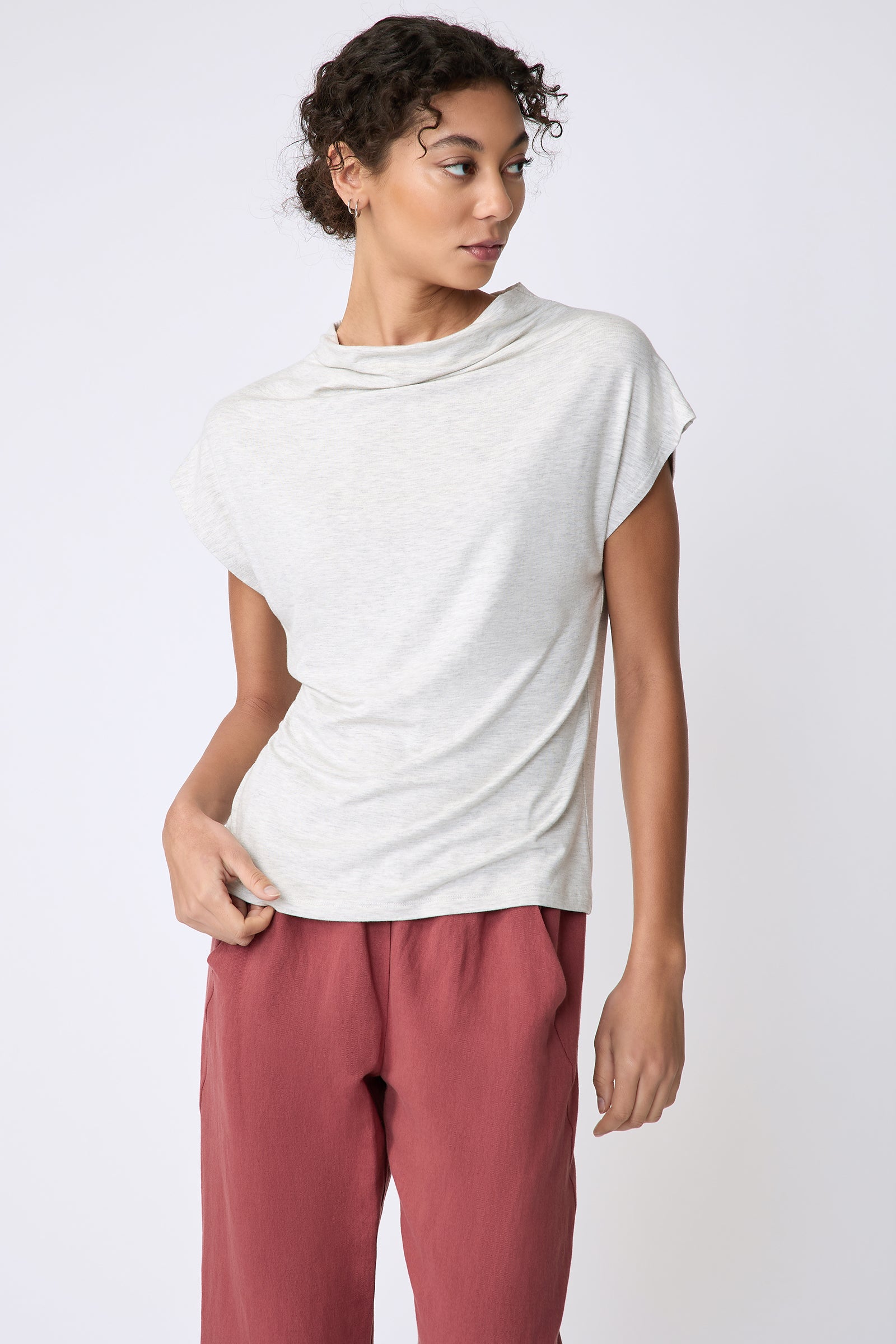Kal Rieman Uma Funnelneck Tee in Oatmeal on model front view holding hem of shirt