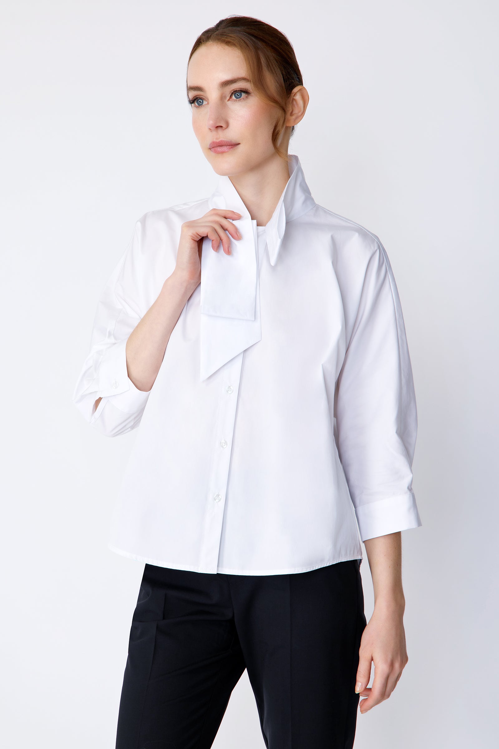 Kal Rieman Vanessa Bow Blouse in white poplin on model side view holding collar