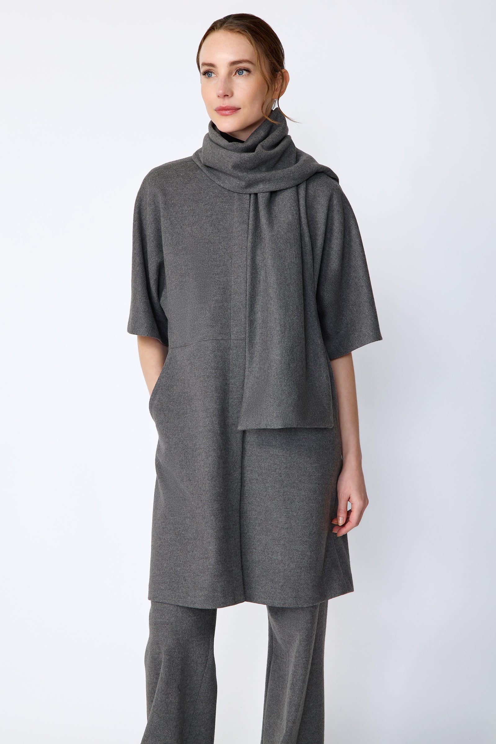 Woman wearing Kal Rieman York Cardigan  in Grey Italian Felted Jersey with Kal Rieman Felted Jersey Wide Leg pants in Grey italian Felted Jersey and burgundy shoes, arm on the side, hand in pocket, close front view,  looking sideways