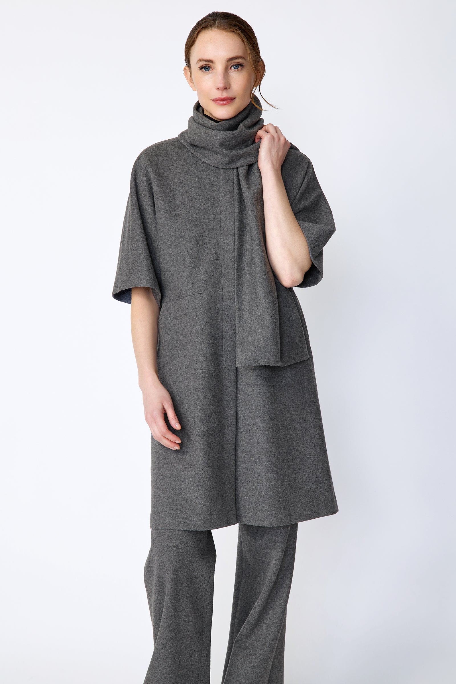 Woman wearing Kal Rieman York Cardigan  in Grey Italian Felted Jersey with Kal Rieman Felted Jersey Wide Leg pants in Grey italian Felted Jersey arm on the side, hand holding scarf, close front view