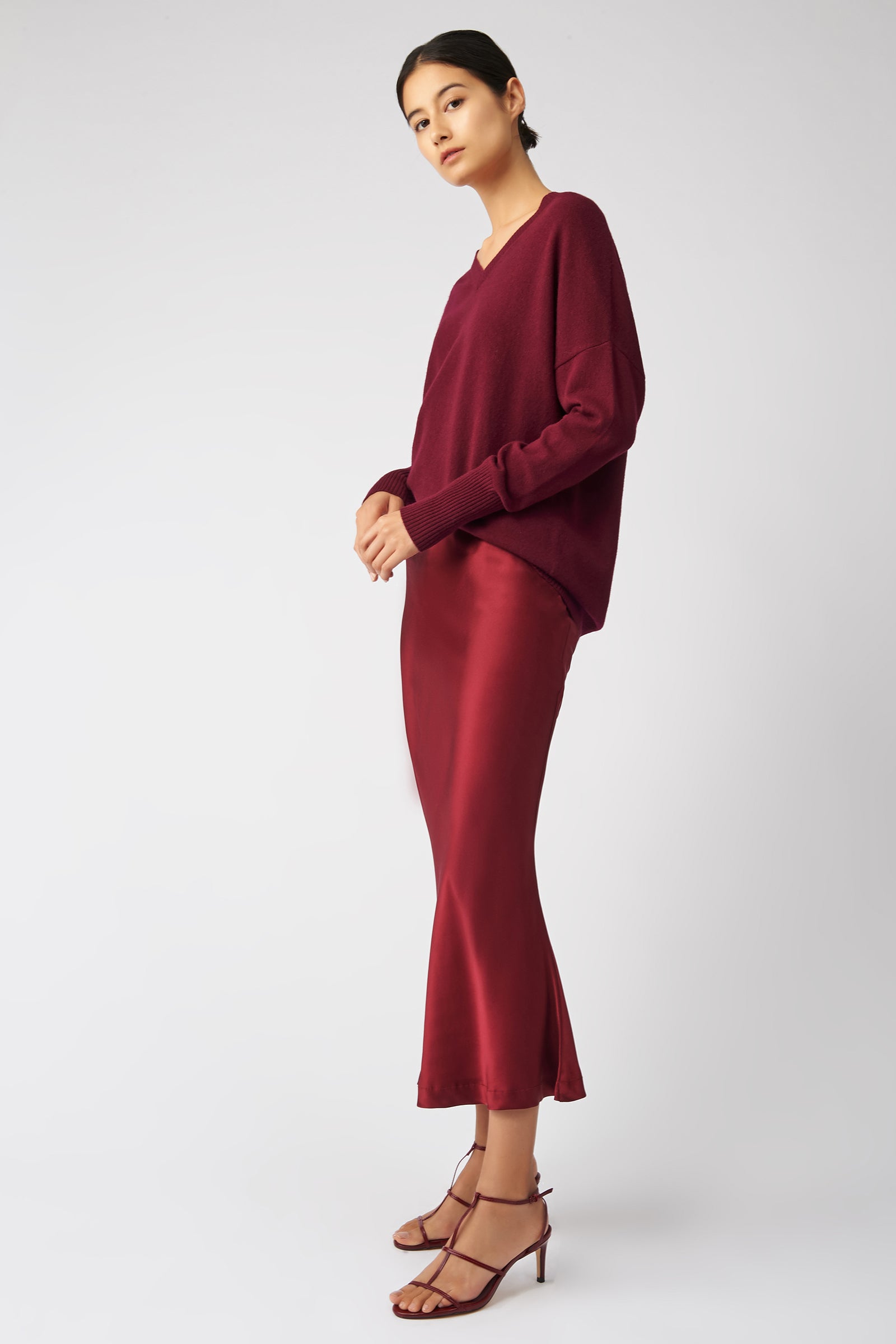 Kal Rieman Bias Silk Skirt in bordeaux on model side view hands in front
