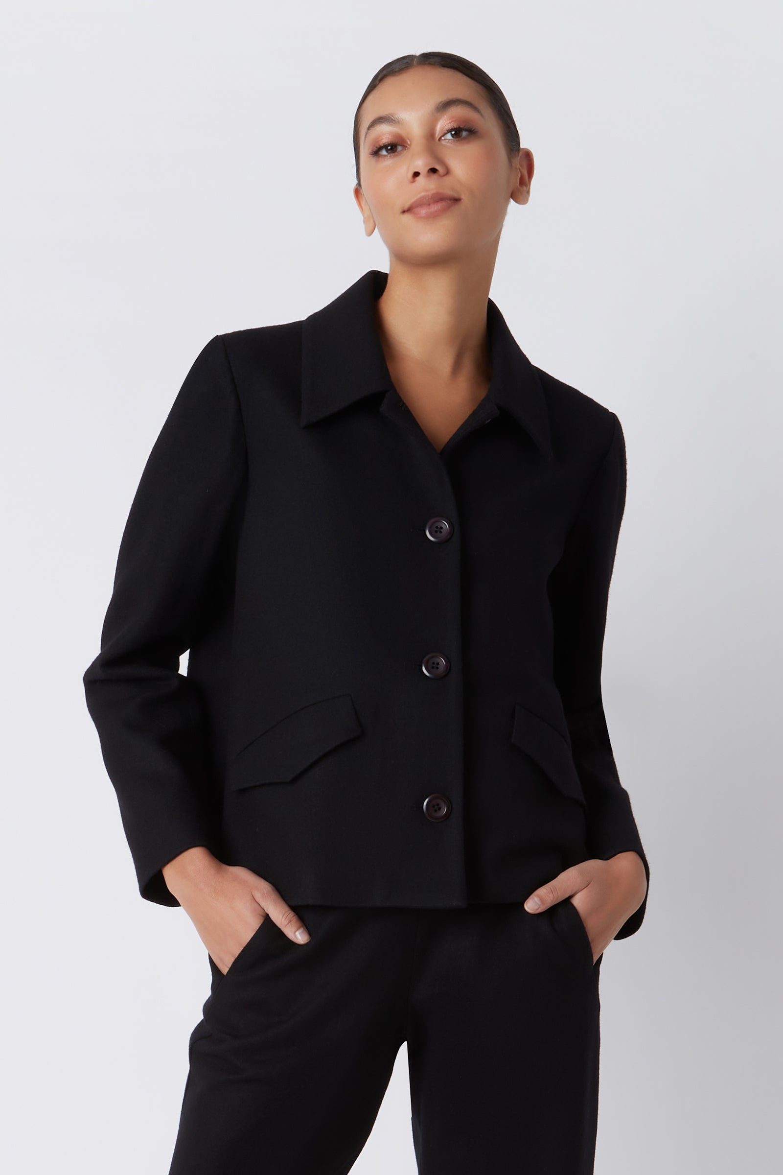 Kal Rieman Sylvie FJ Swing Jacket in Black Felted Jersey on Model with Hands in Pockets Cropped Front View