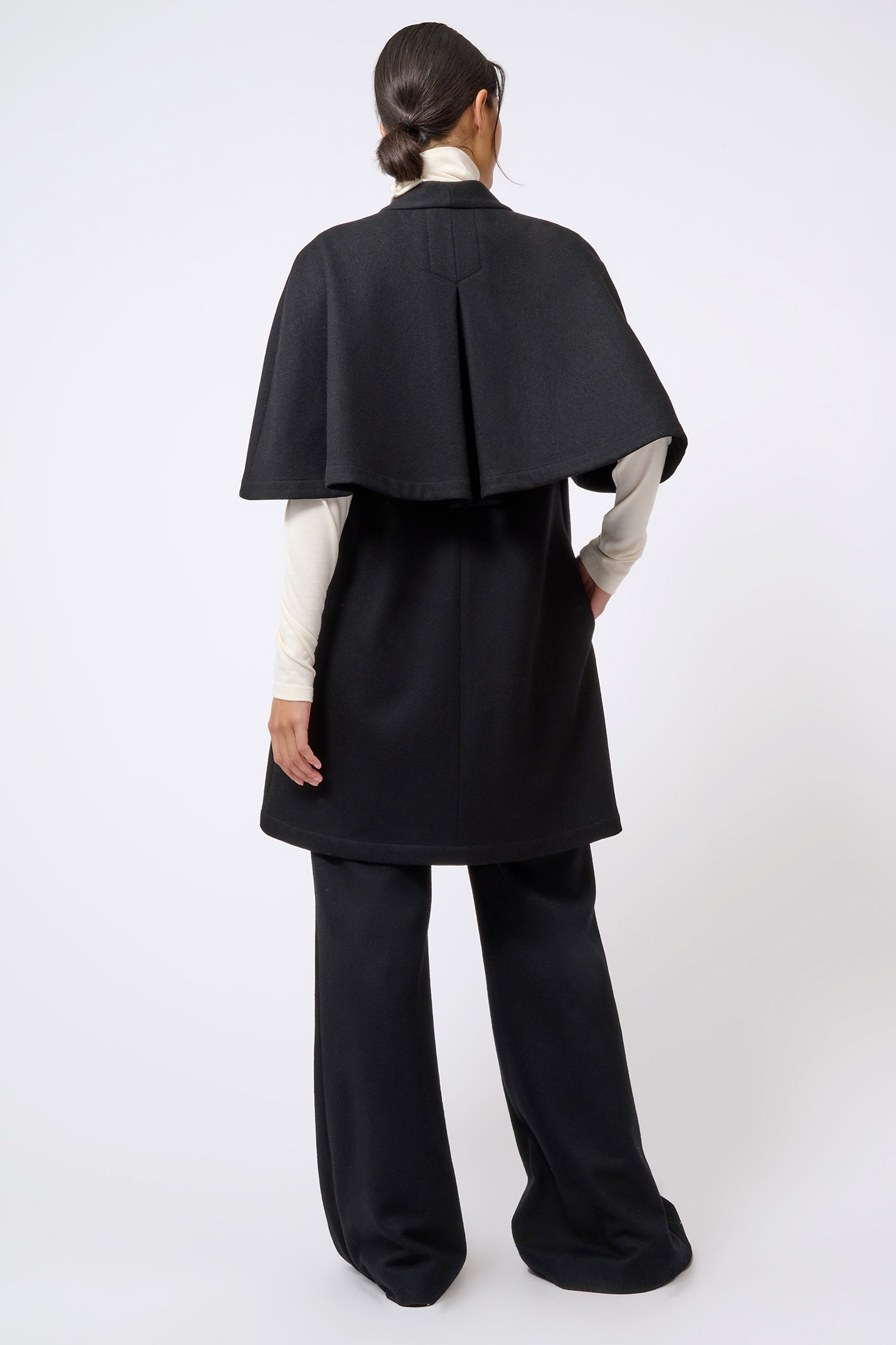 Kal Rieman Cape Back Cardigan in Black on Model with Hands in Pockets Full Front View