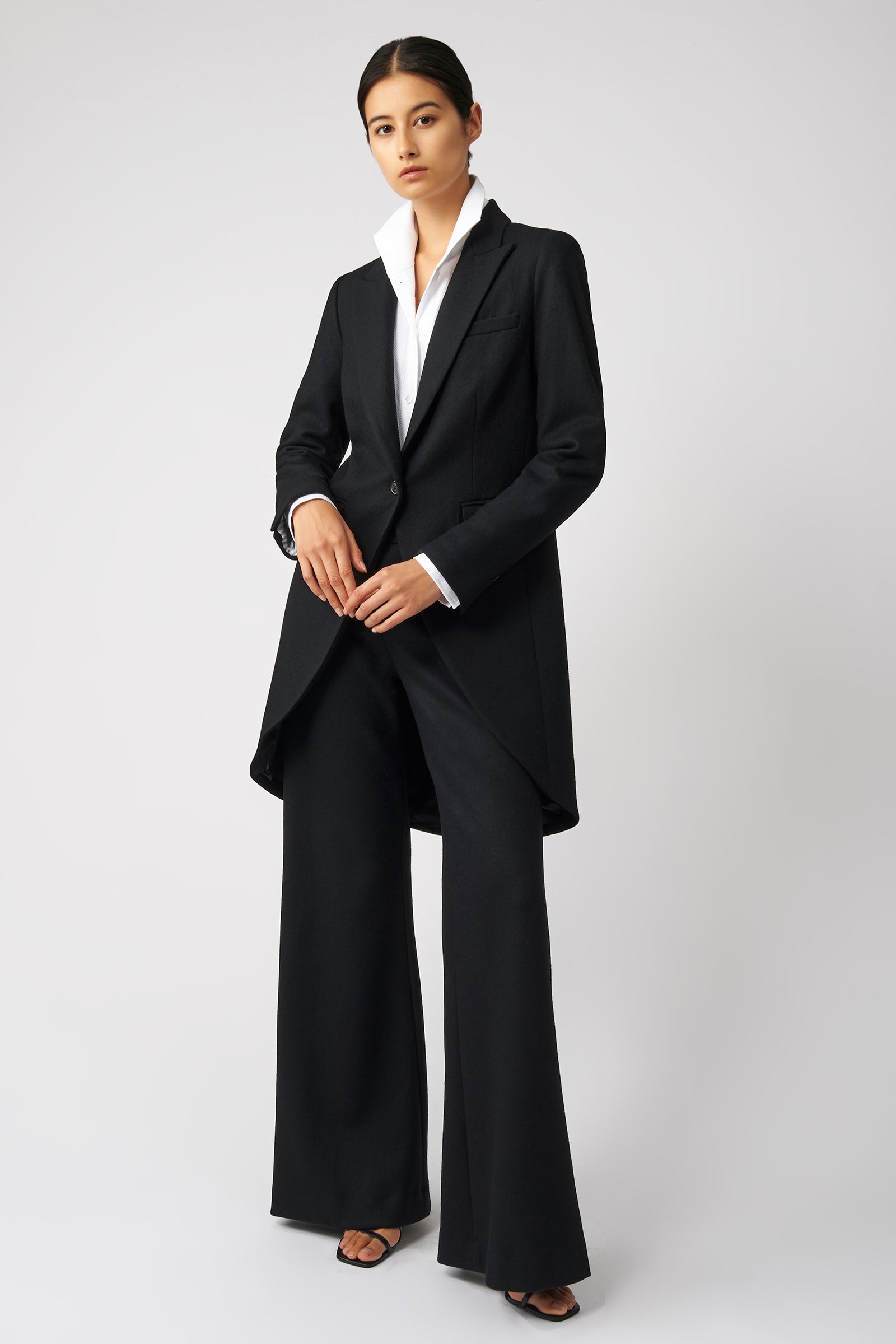 Woman wearing Kal Rieman Tailored Tux Blazer in Black, with Kal Rieman Wide Leg Pants in Black, holding hands in the front