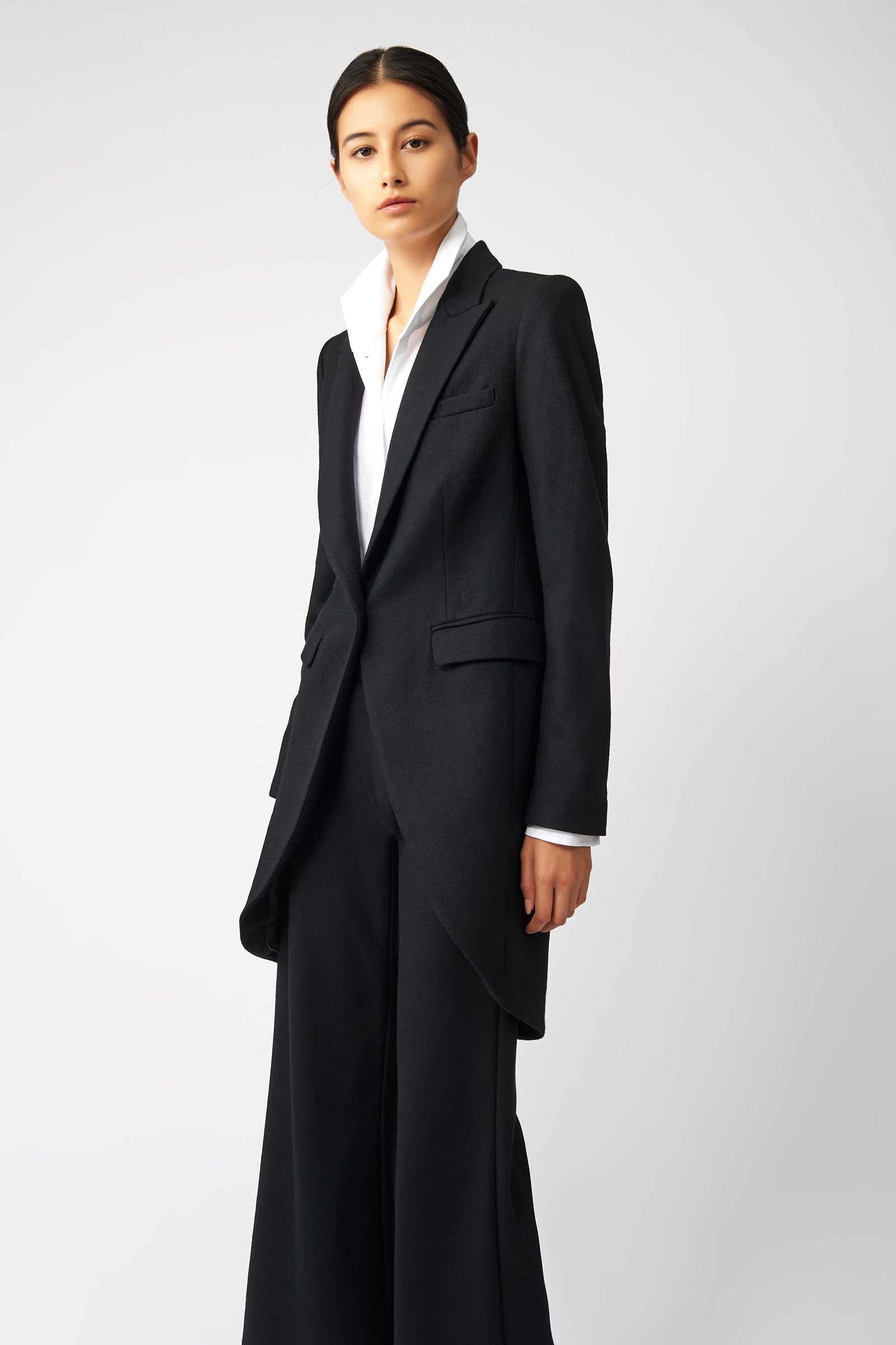 Woman wearing Kal Rieman Tailored Tux Blazer in Black with Kal Rieman Wide Leg Pants in Black, arms on the side