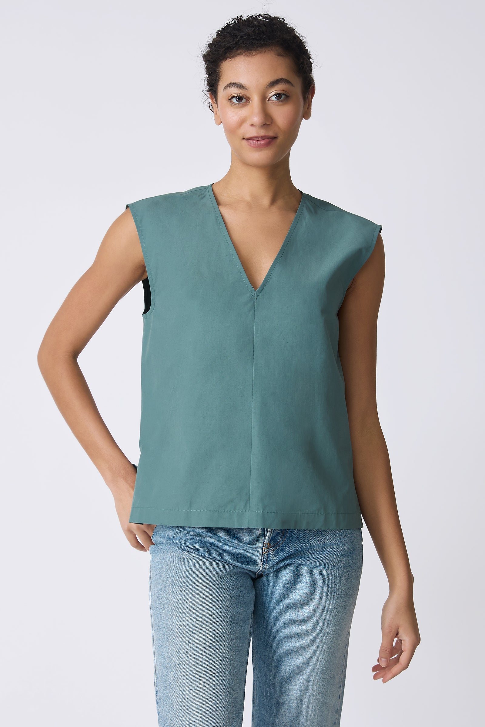 Ava V-Neck Shell Top in Sage on model with hand in back pocket front view