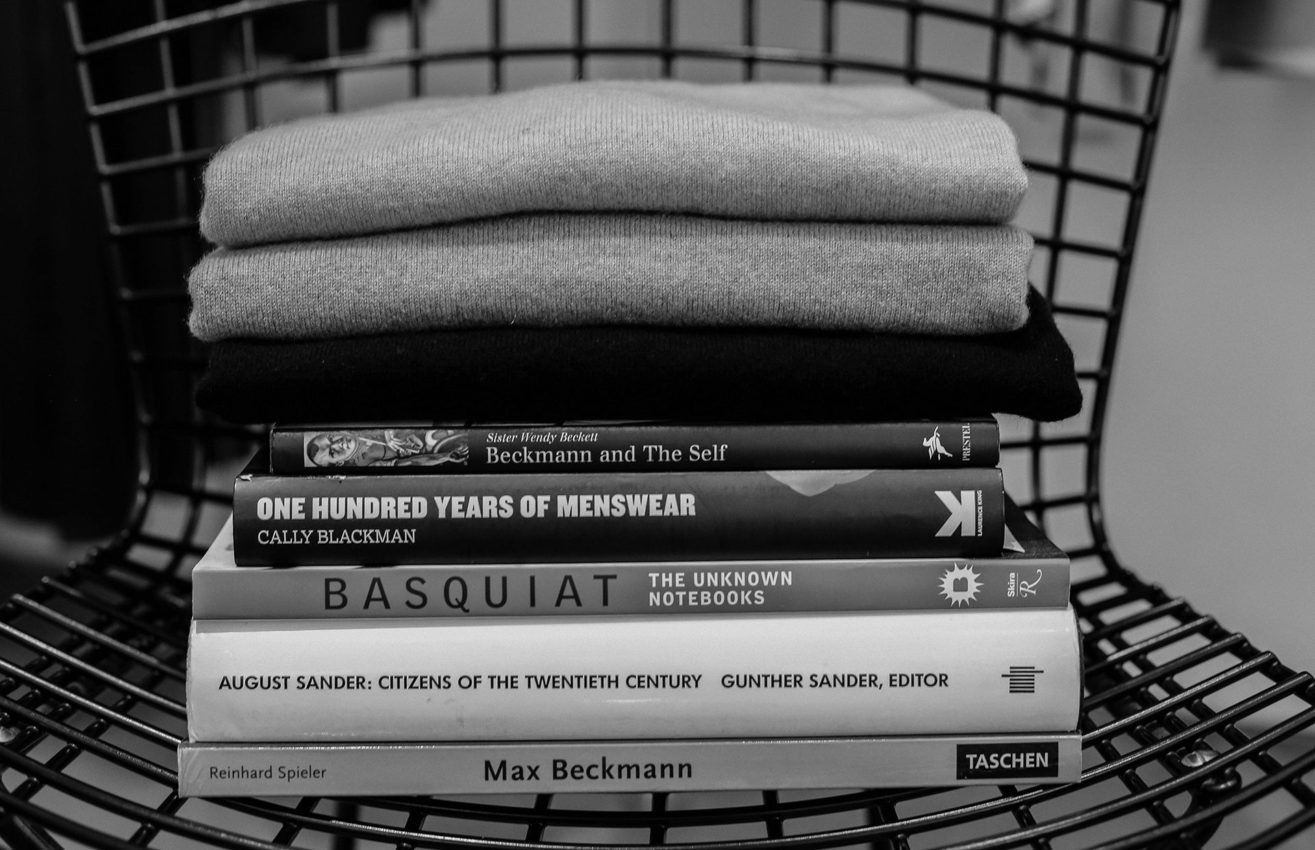 Kal Rieman image of cashmere sweaters sitting on a stack of books