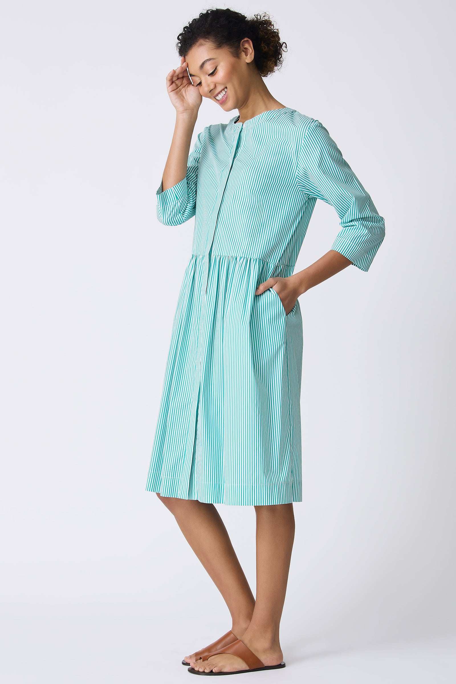 Kal Rieman Abby Shirt Dress in Miami Stripe Green on model smiling and looking down full side view