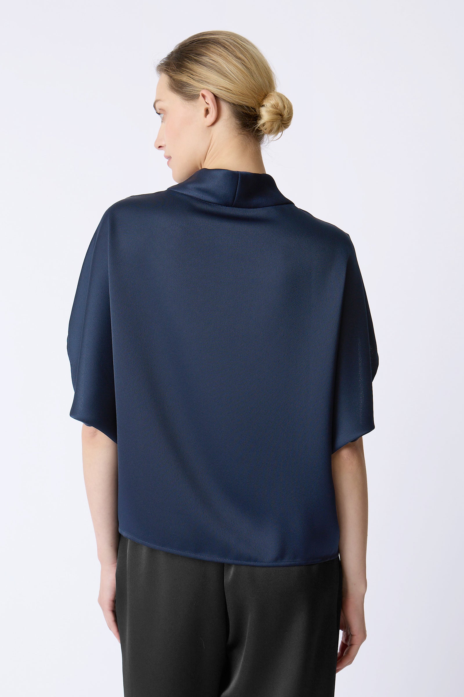 Kal Rieman Angelica Cape Top in Navy on model with hand touching collar front view