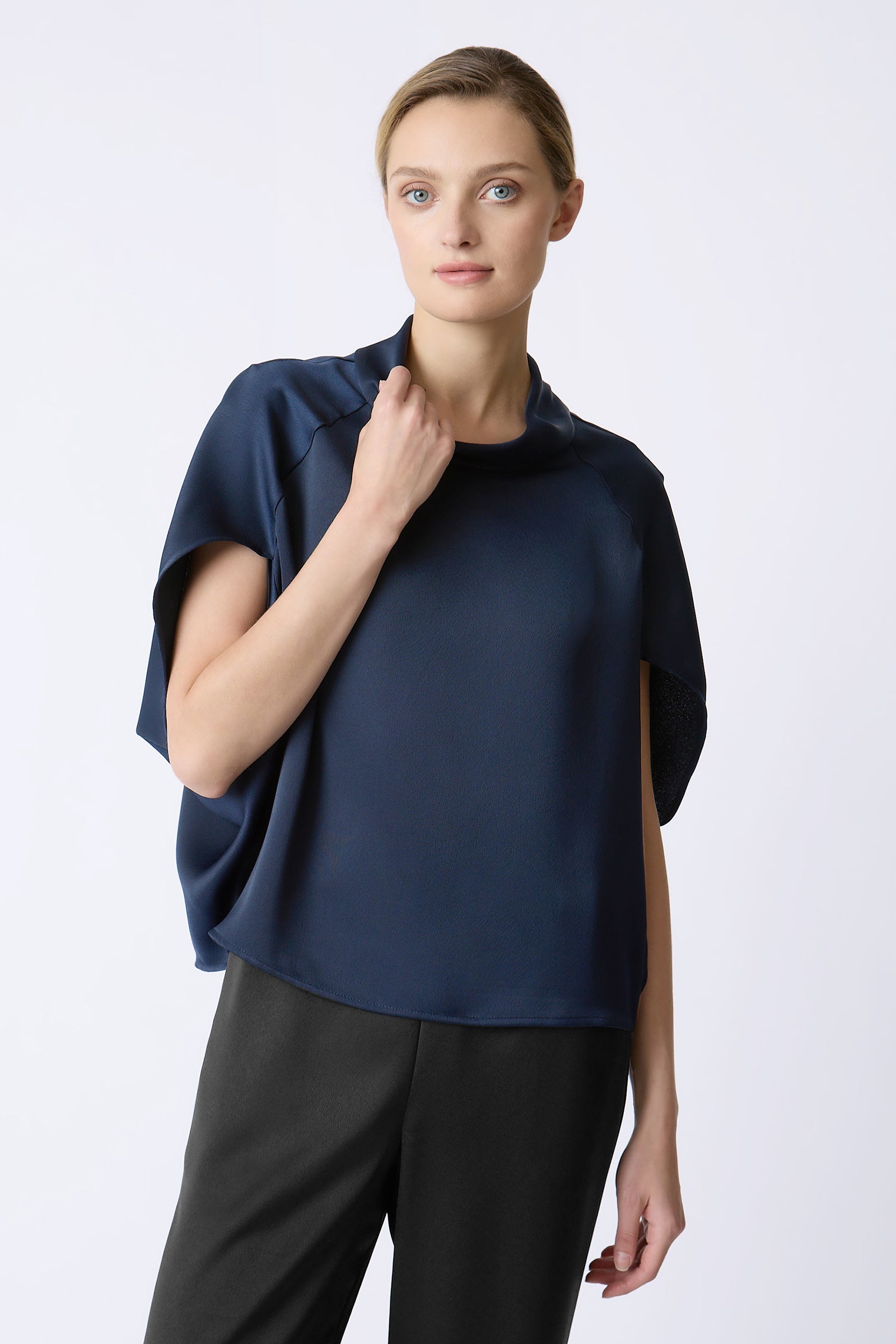 Kal Rieman Angelica Cape Top in Navy on model with hand touching collar front view