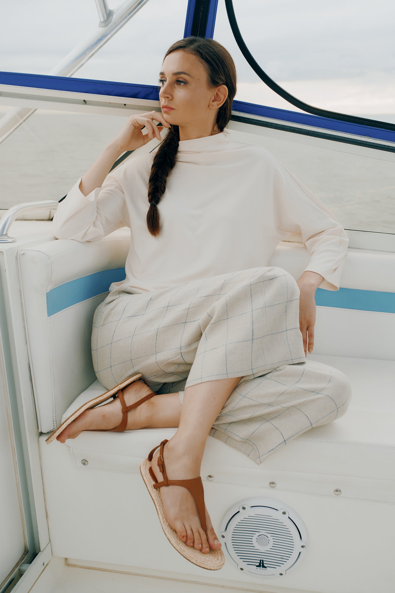 Kal Rieman Brigitte Mock Funnel Top in Ivory on model sitting on boat