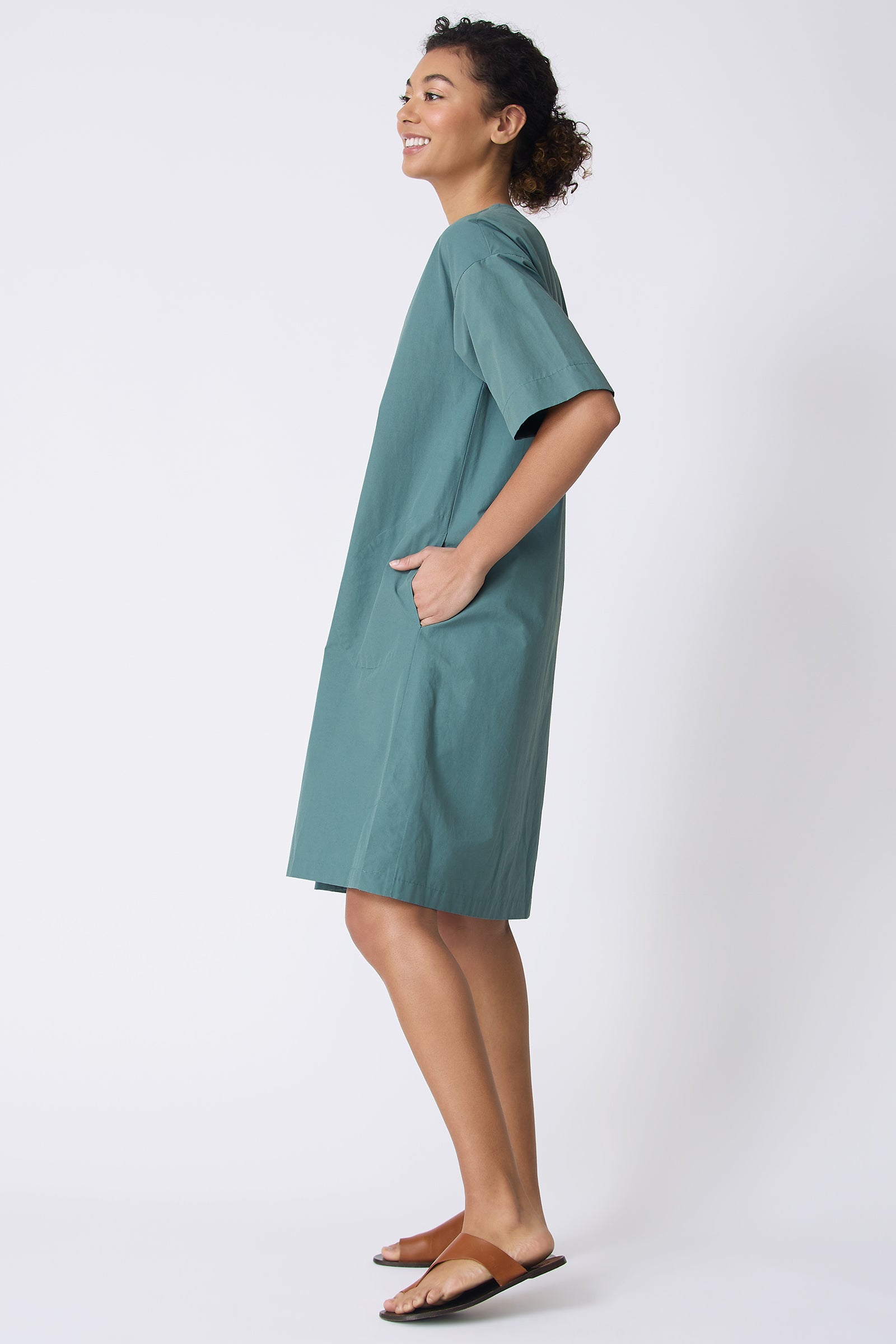 Kal Rieman Cara Fold Front Dress in Sage on model with hand in pocket full side view