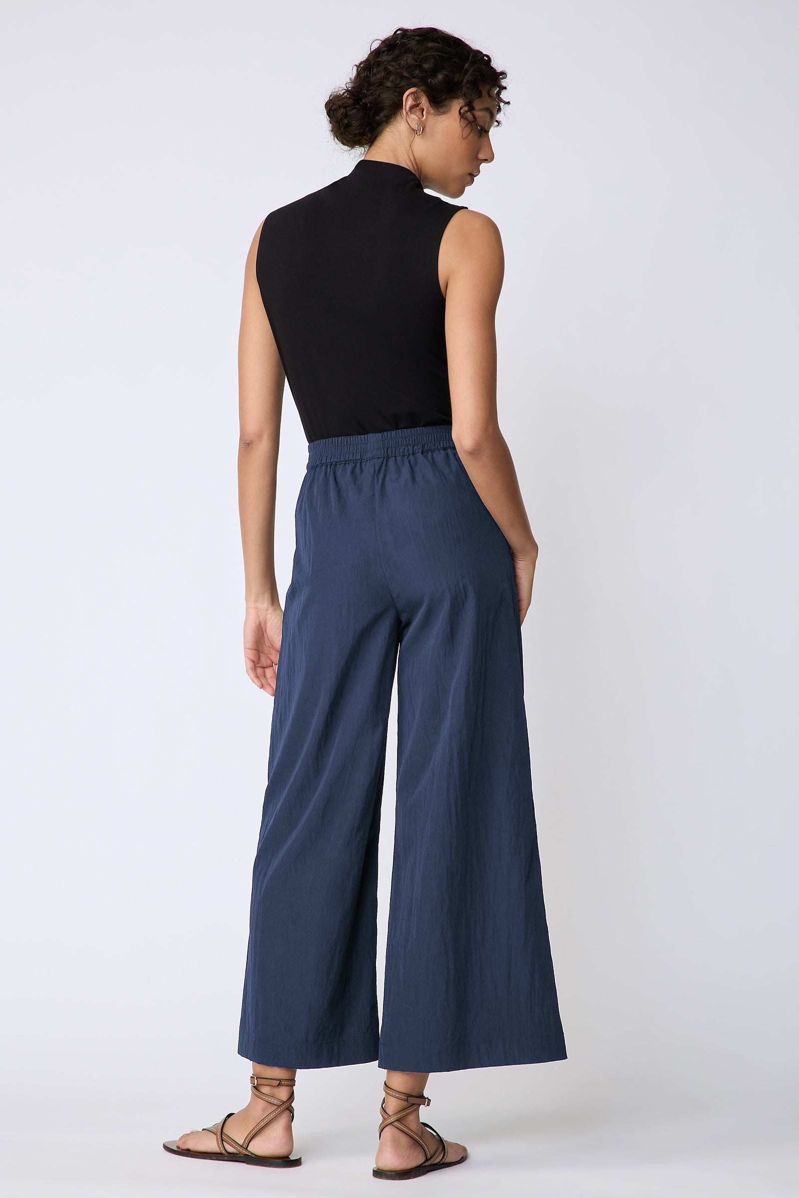 Kal Rieman Celeste Pant in navy typewriter cloth on model side view walking