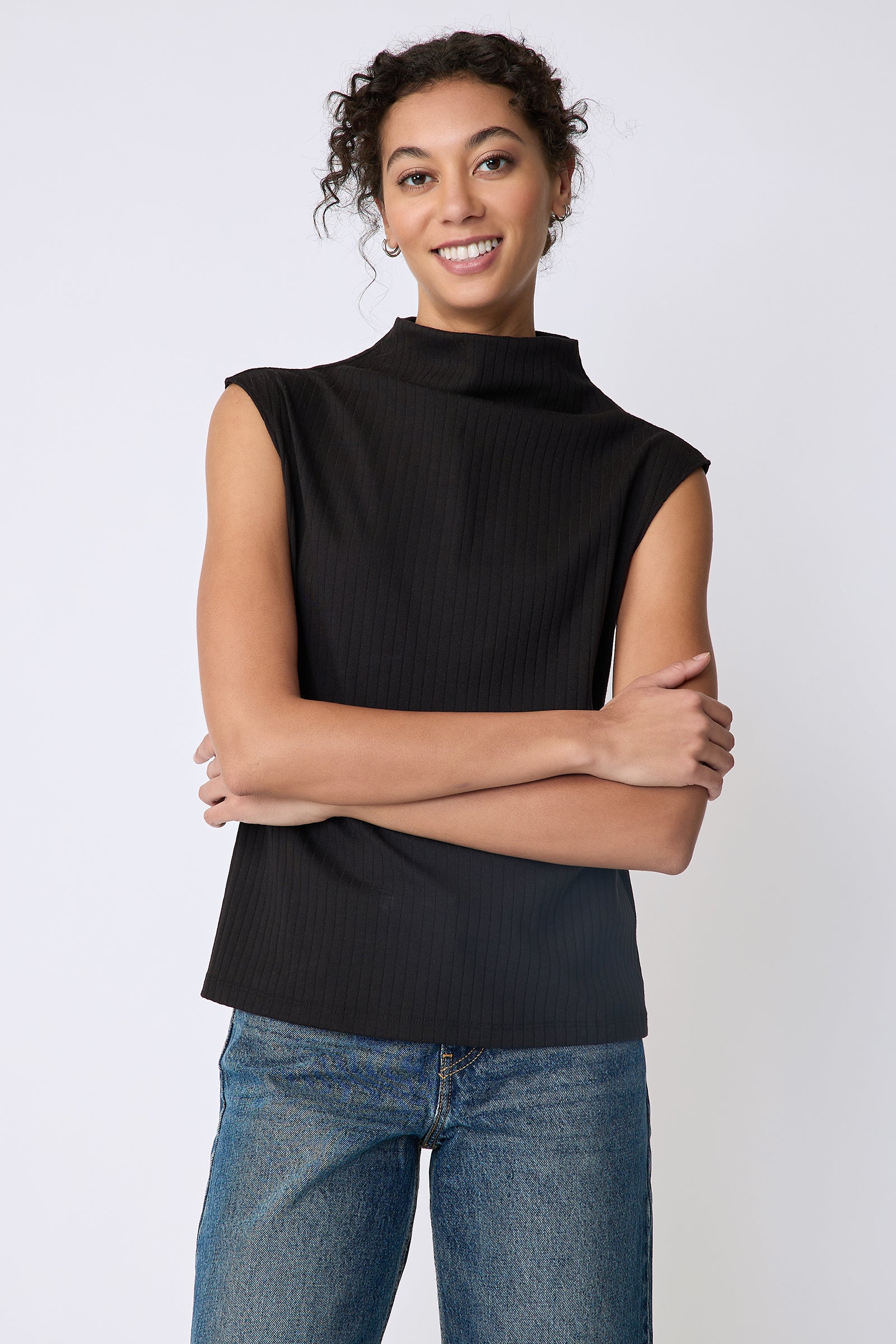 Kal Rieman Eva Funnelneck top in black rib knit on model front view arms crossed