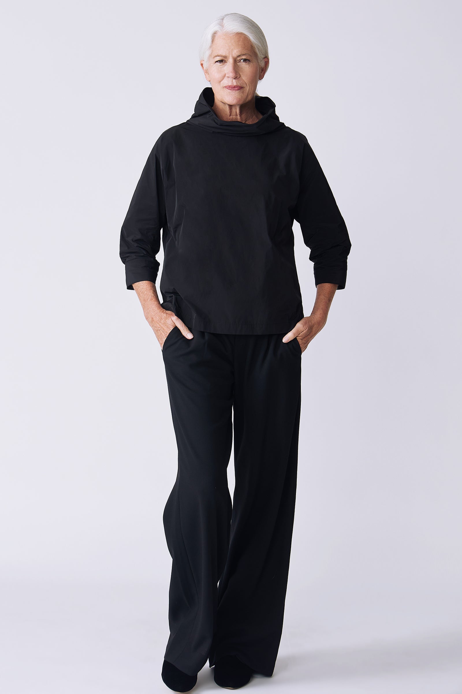 Kal Rieman Julia Taffeta Top in black on model front view walking hands in pockets