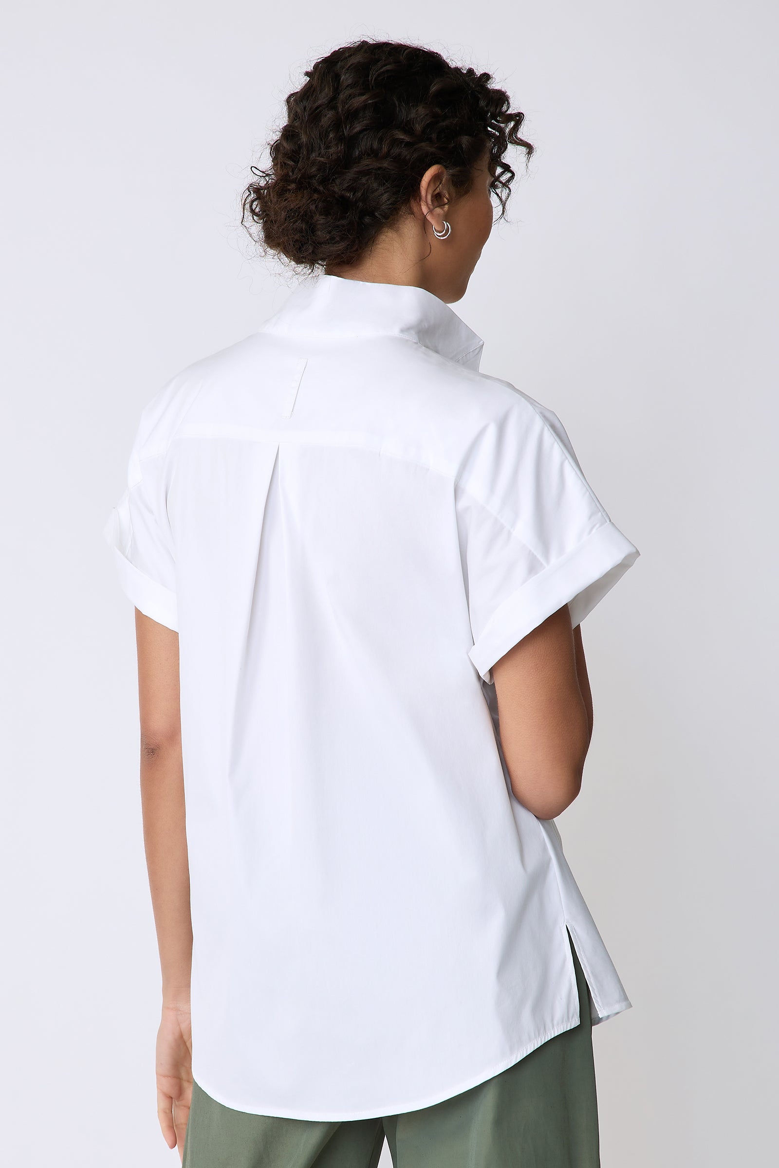 Kal Rieman Mila Wrap Top in white stretch cotton on model front view full look hands behind her back