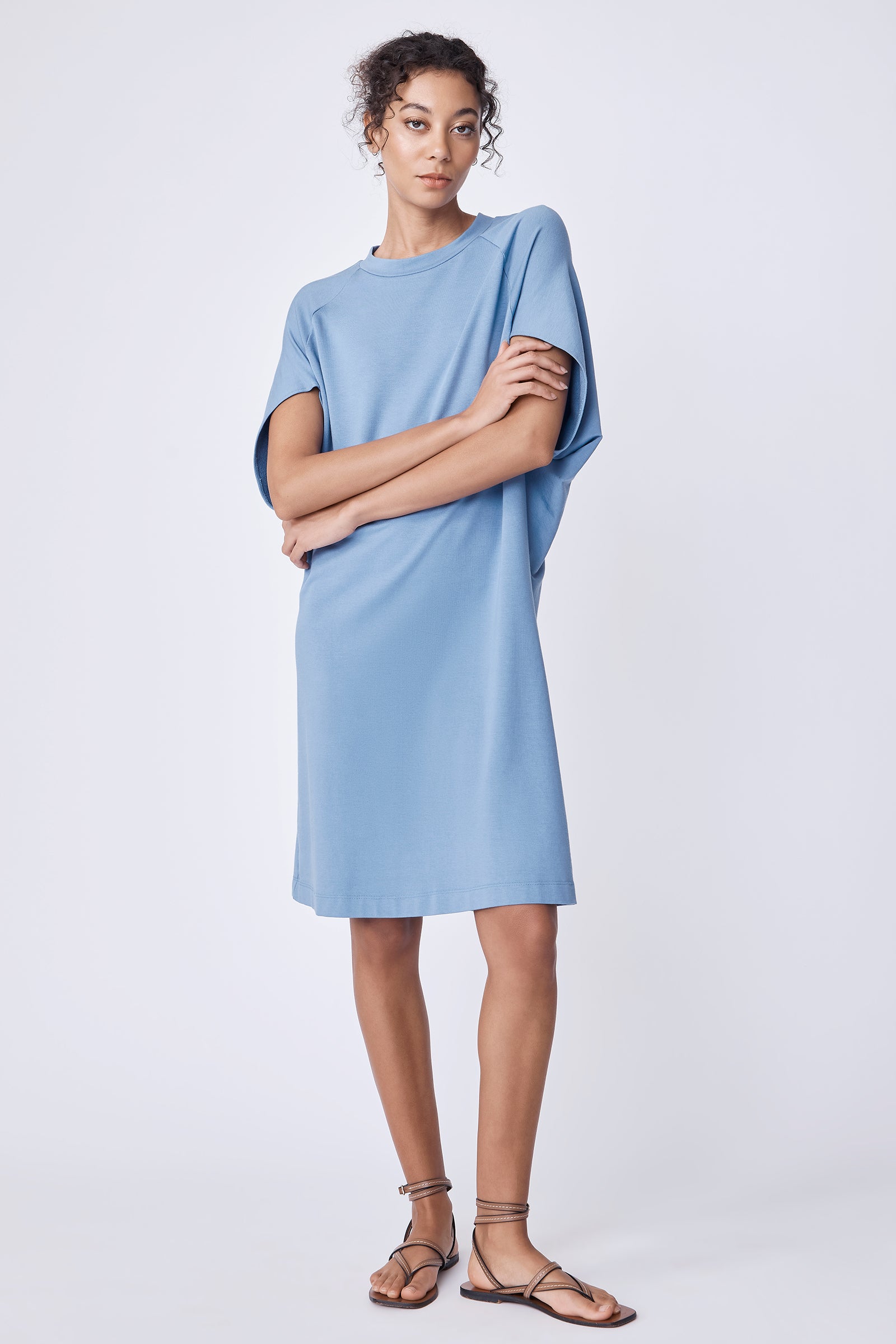 Kal Rieman Phoenix Cape Dress in sky blue bamboo terry on model with arms crossed full front view
