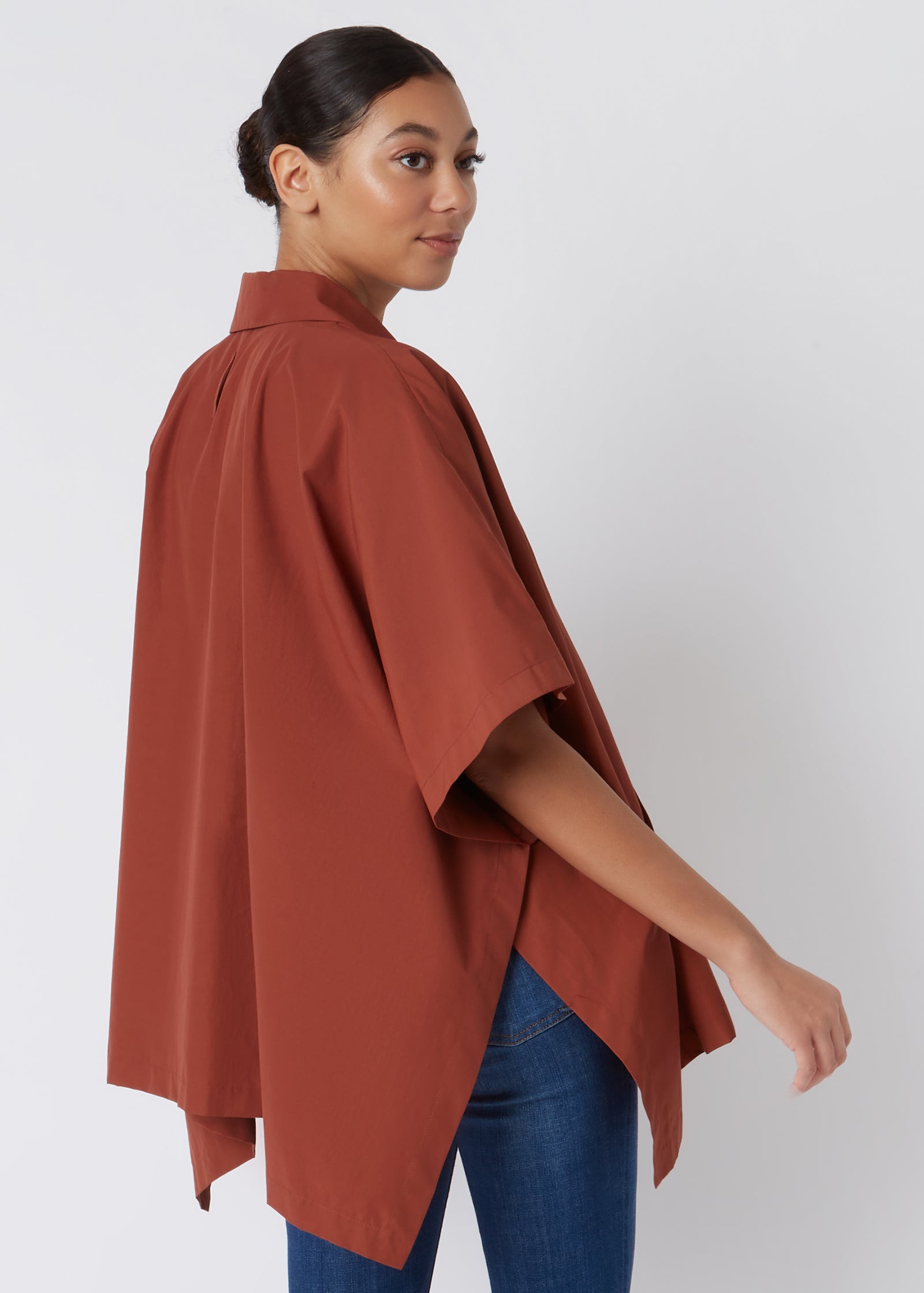 Kal Rieman Pocket Poncho in Rust Italian Broadcloth on Model with Hands in Pockets Cropped Front View