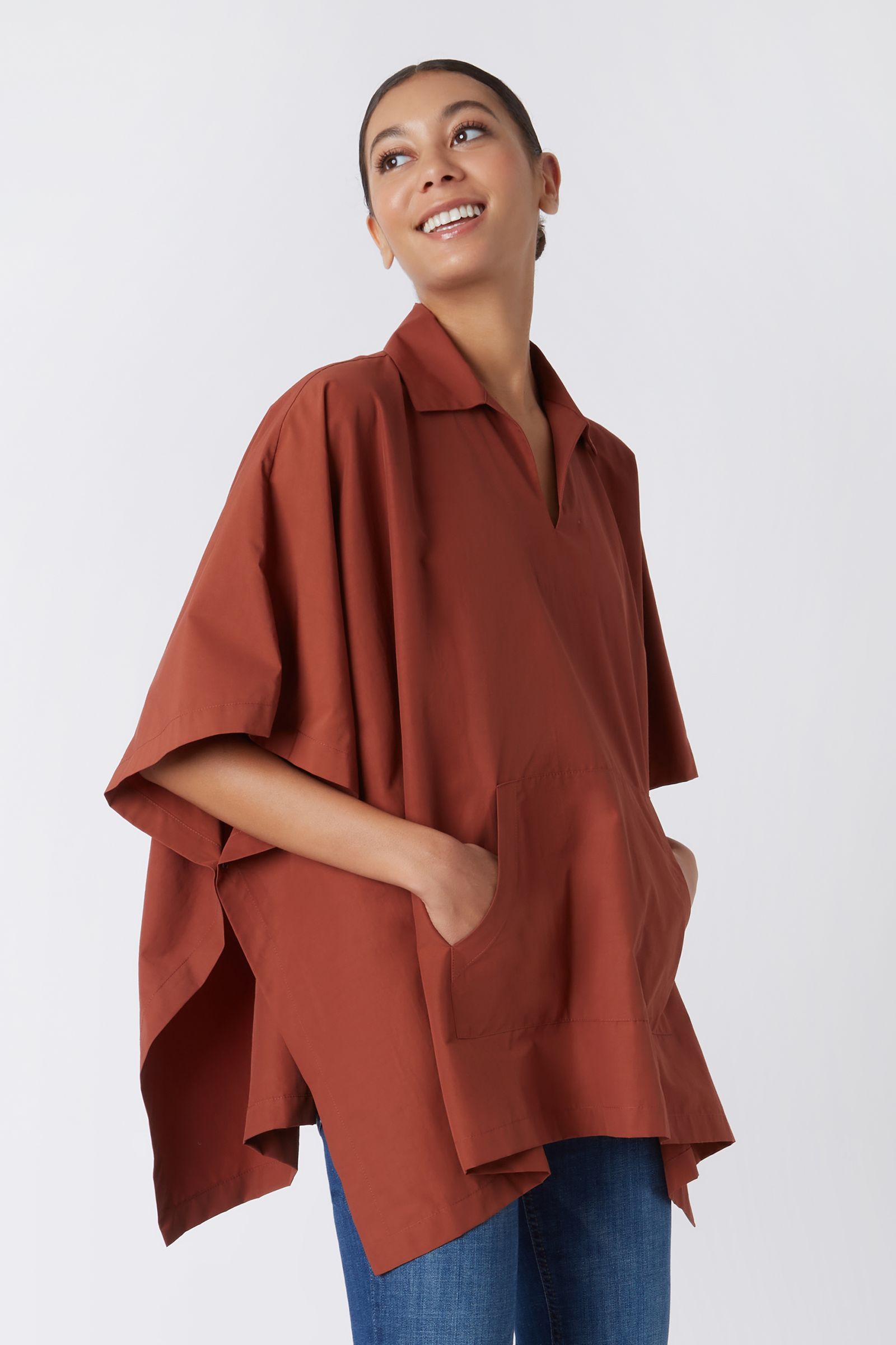 Kal Rieman Pocket Poncho in Rust Italian Broadcloth on Model with Hands in Pockets Cropped Side View