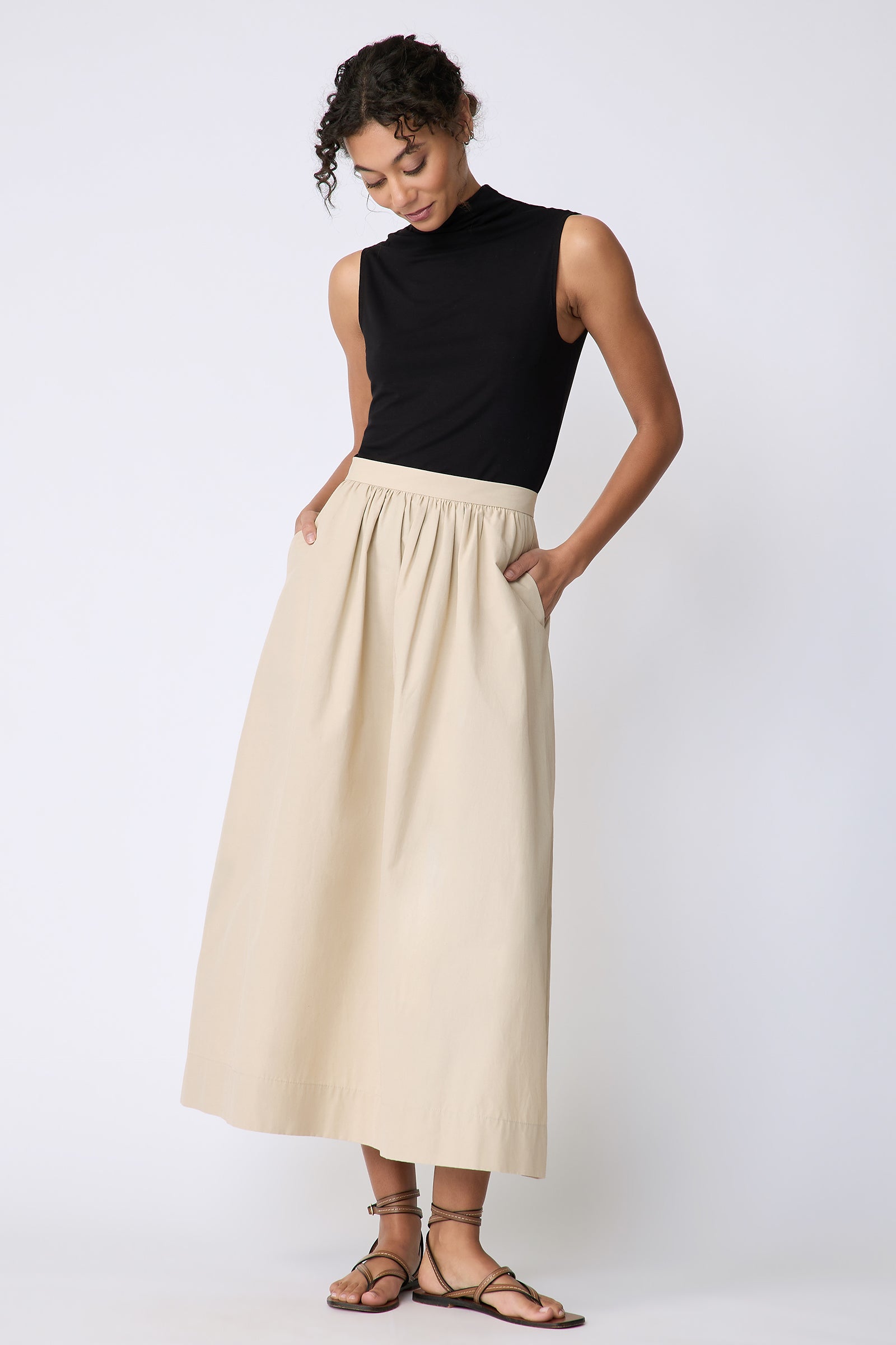 Kal Rieman Sadie Skirt in Italian Broadcloth color sand on model front view hands in pockets