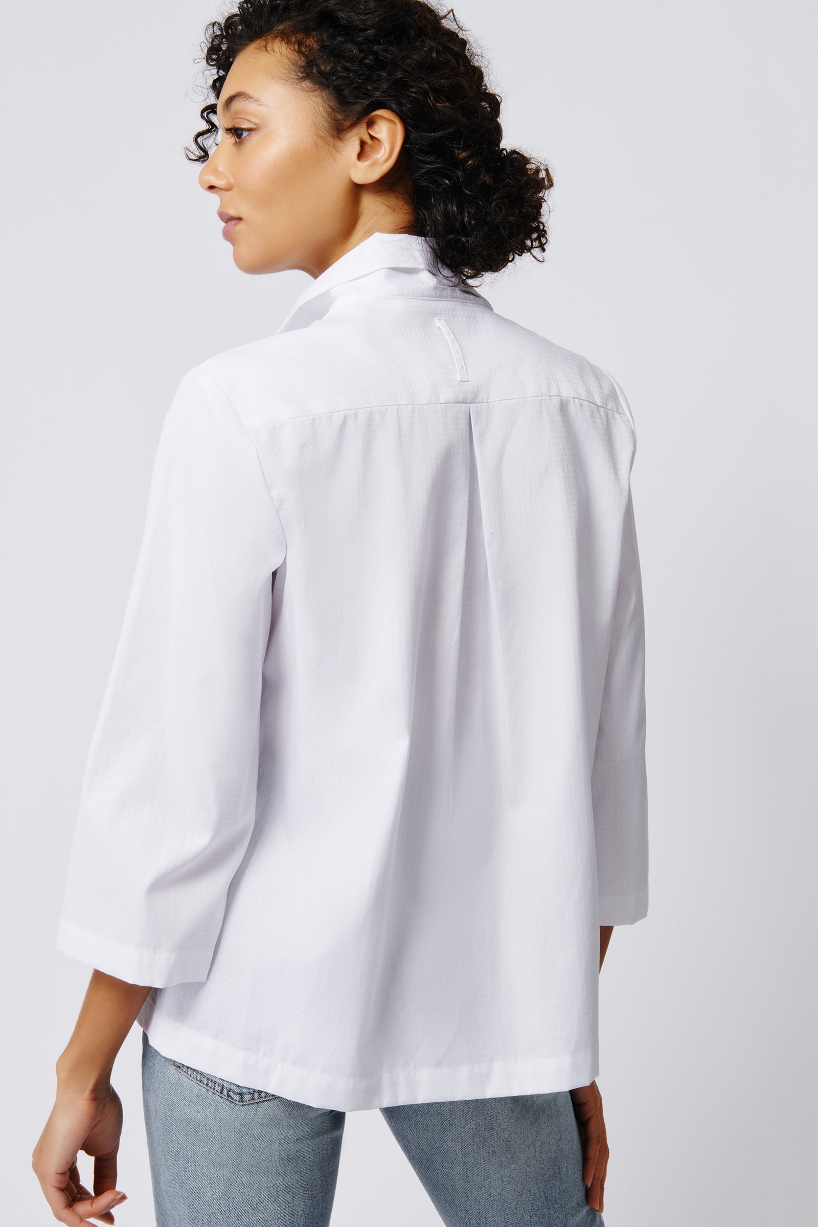 Kal Rieman 3/4 sleeve Ginna shirt in white stretch on model back view hands crossed